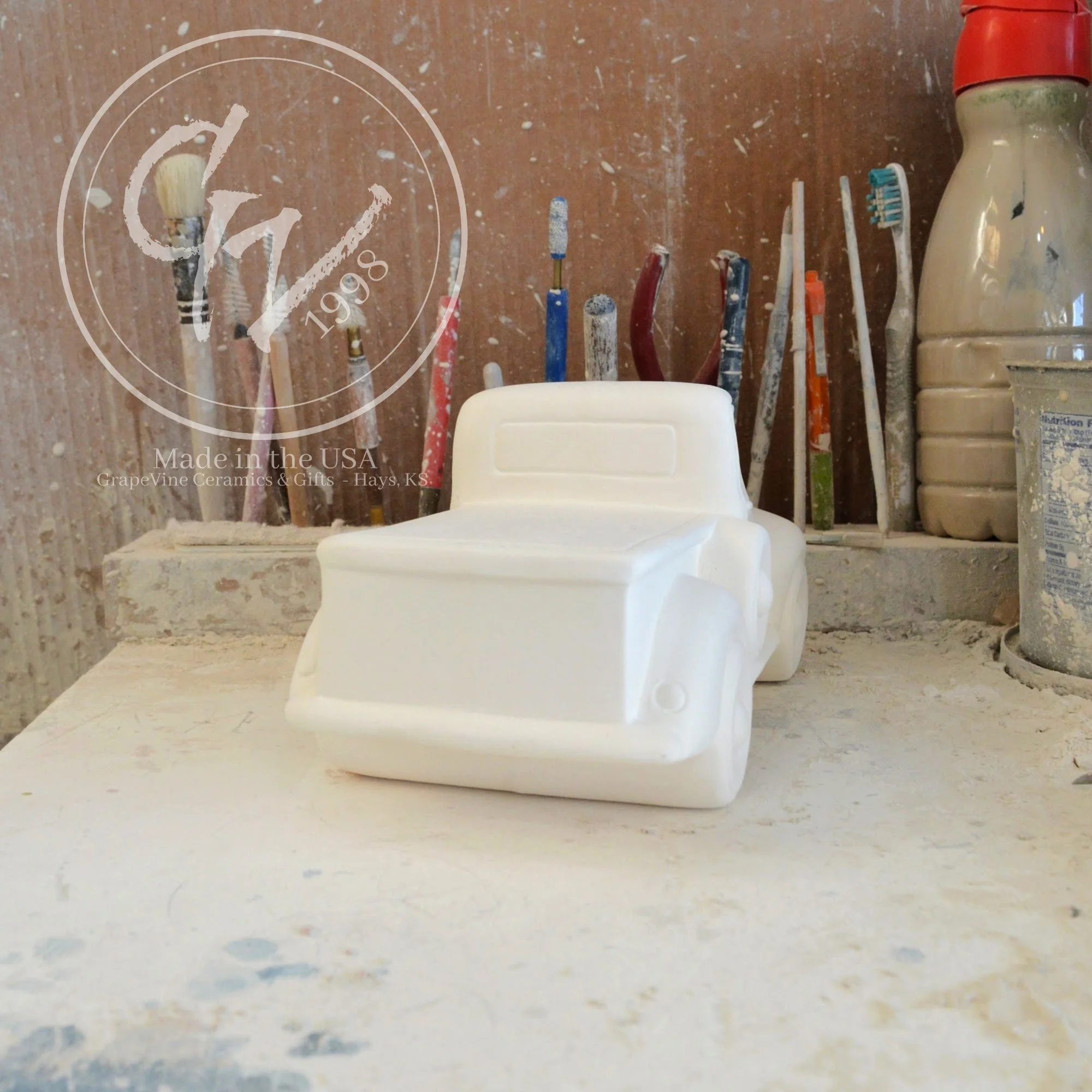 Unpainted white ceramic pickup truck bisque, rear view, ready for DIY painting.