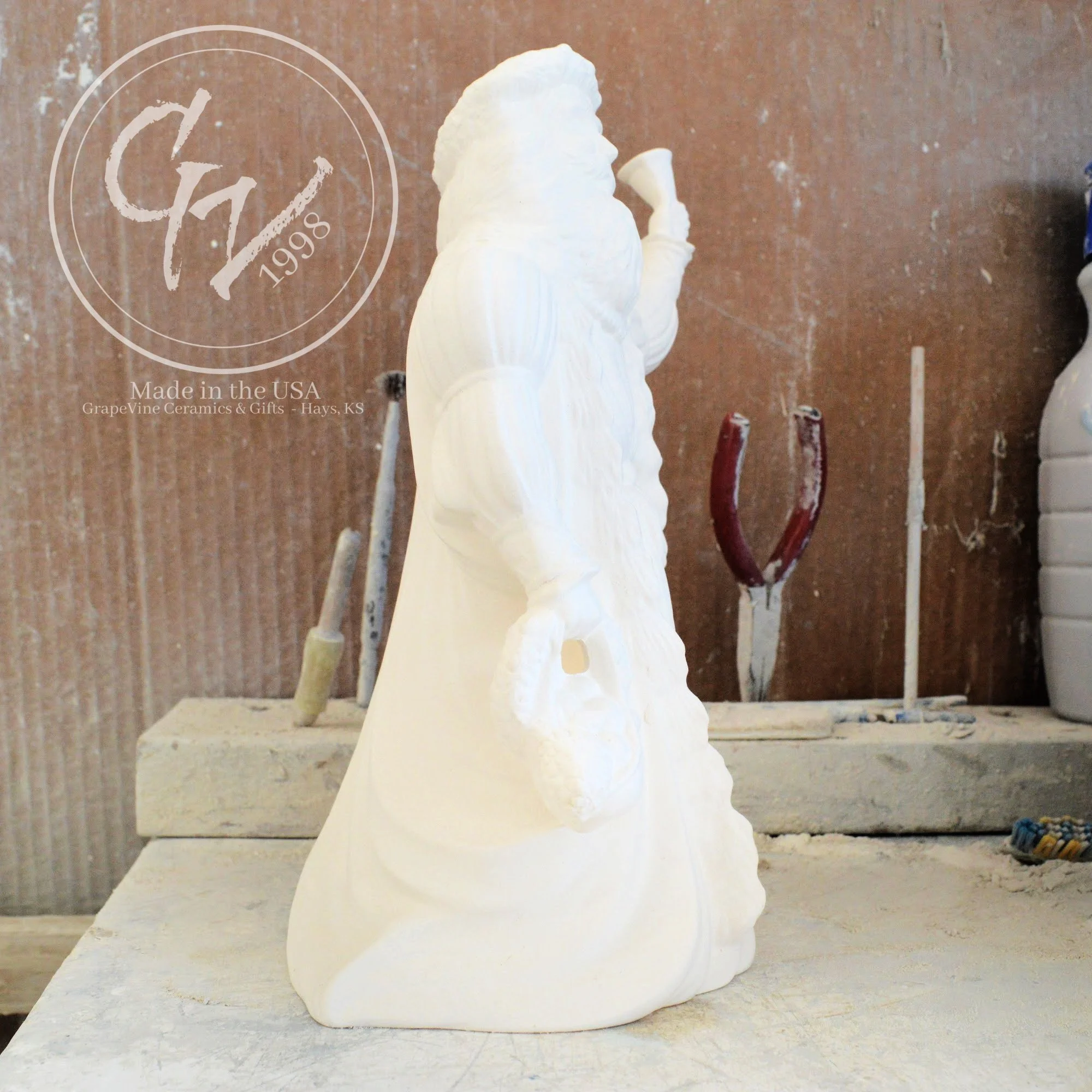 Side view of the Old English Santa bisque showing the flowing textures of the traditional hooded cloak.