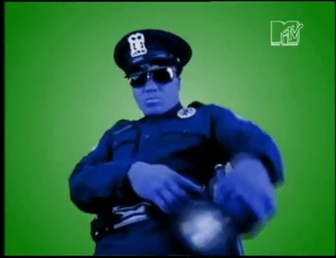 Person in police uniform with blue skin effect and sunglasses against green background.