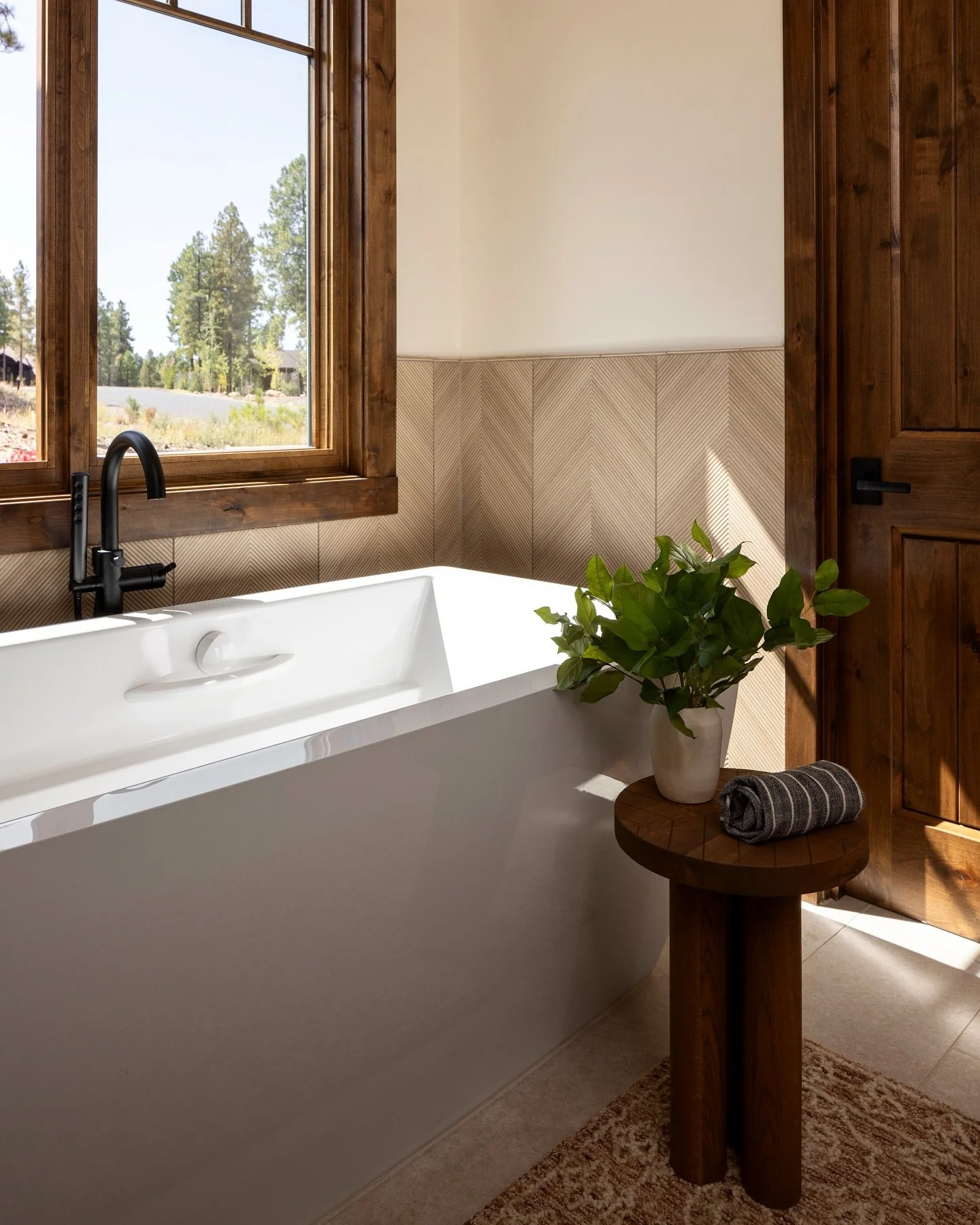 Setting the tone for a relaxing weekend from our Pine Canyon home. The alpine setting grounds you, while luxe touches such as the soaking tub and herringbone tiles elevate this space. ⁠#LygiaHarkinsInteriors⁠ ⁠
⁠
⁠
#interiordesign #interiordesigner #