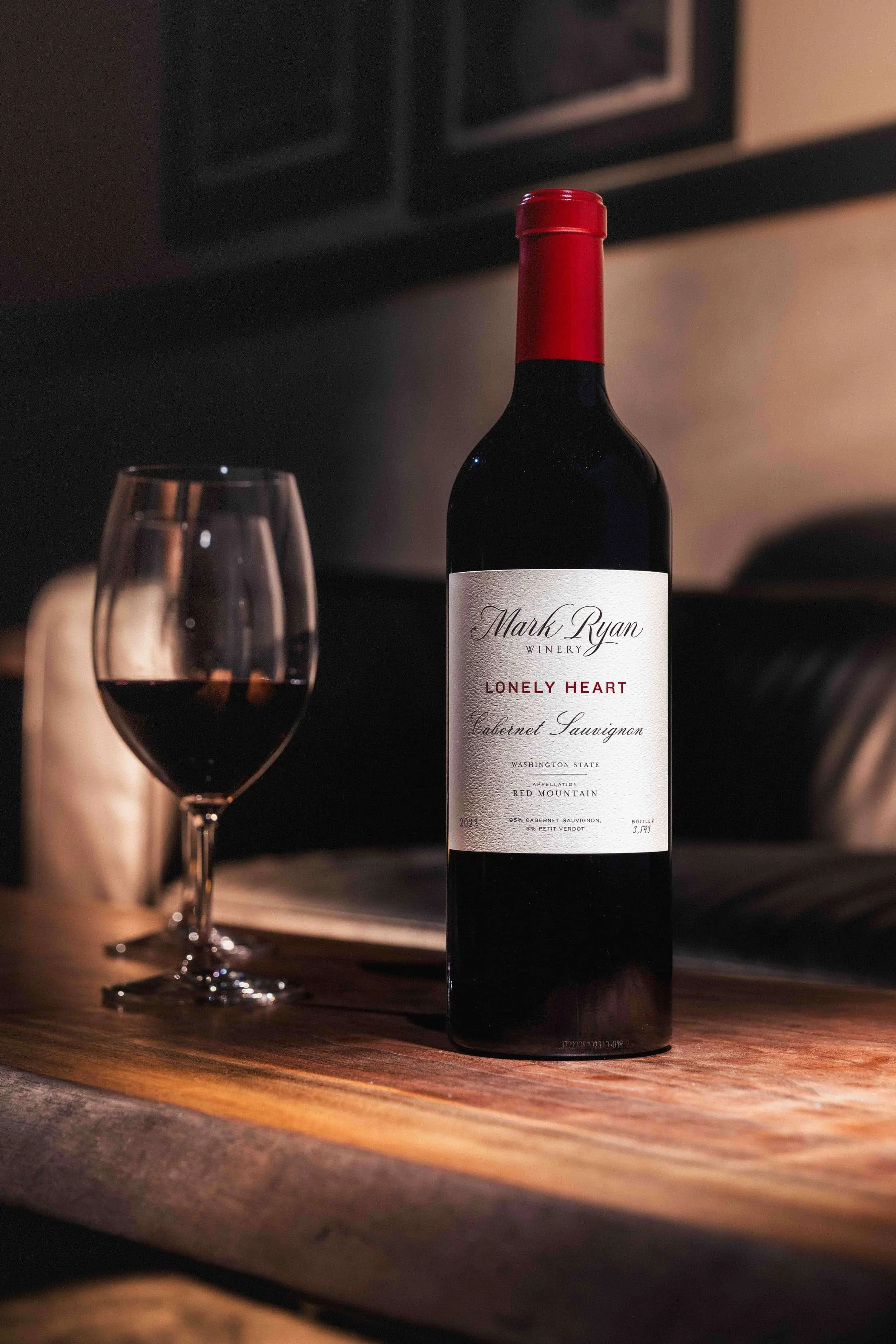 Bottle of Mark Ryan Lonely Heart Cabernet Sauvignon next to a glass of wine.