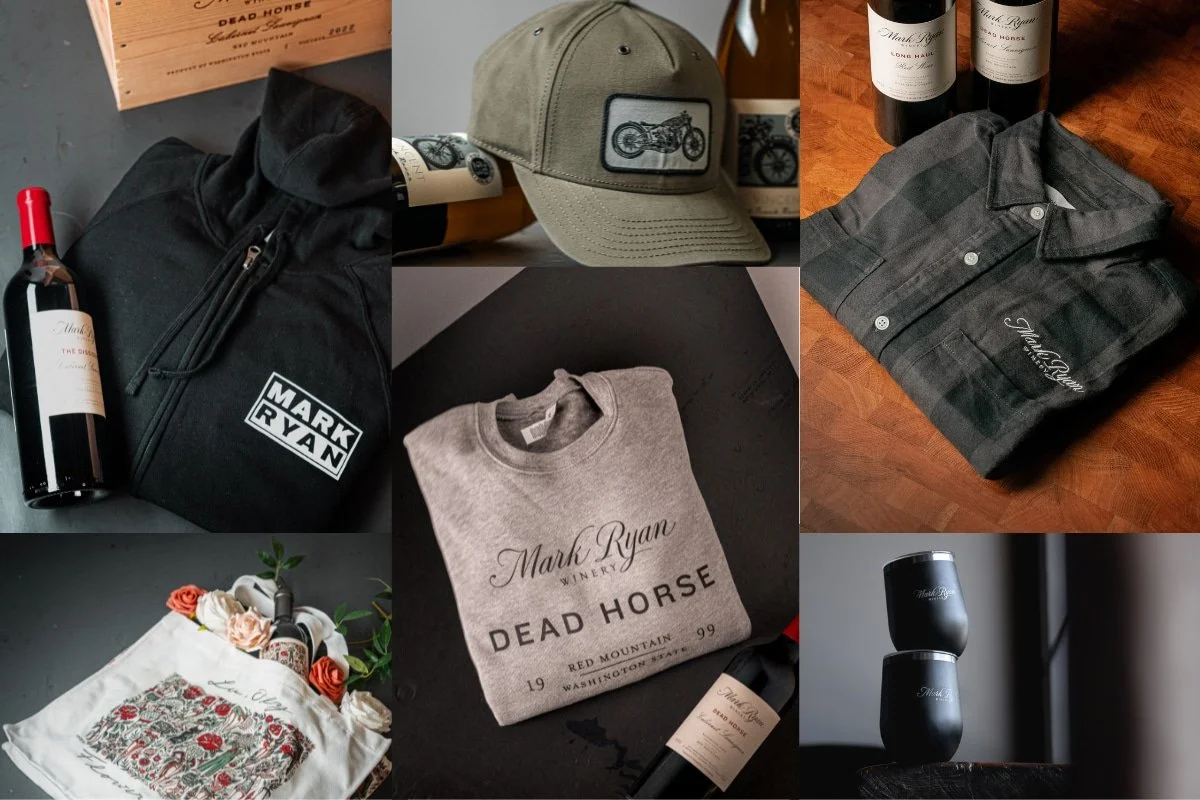 Collection of branded products including clothing, wine bottles, a hat, a sweatshirt, and accessories from Mark Ryan Winery, with decorative flowers and packaging.