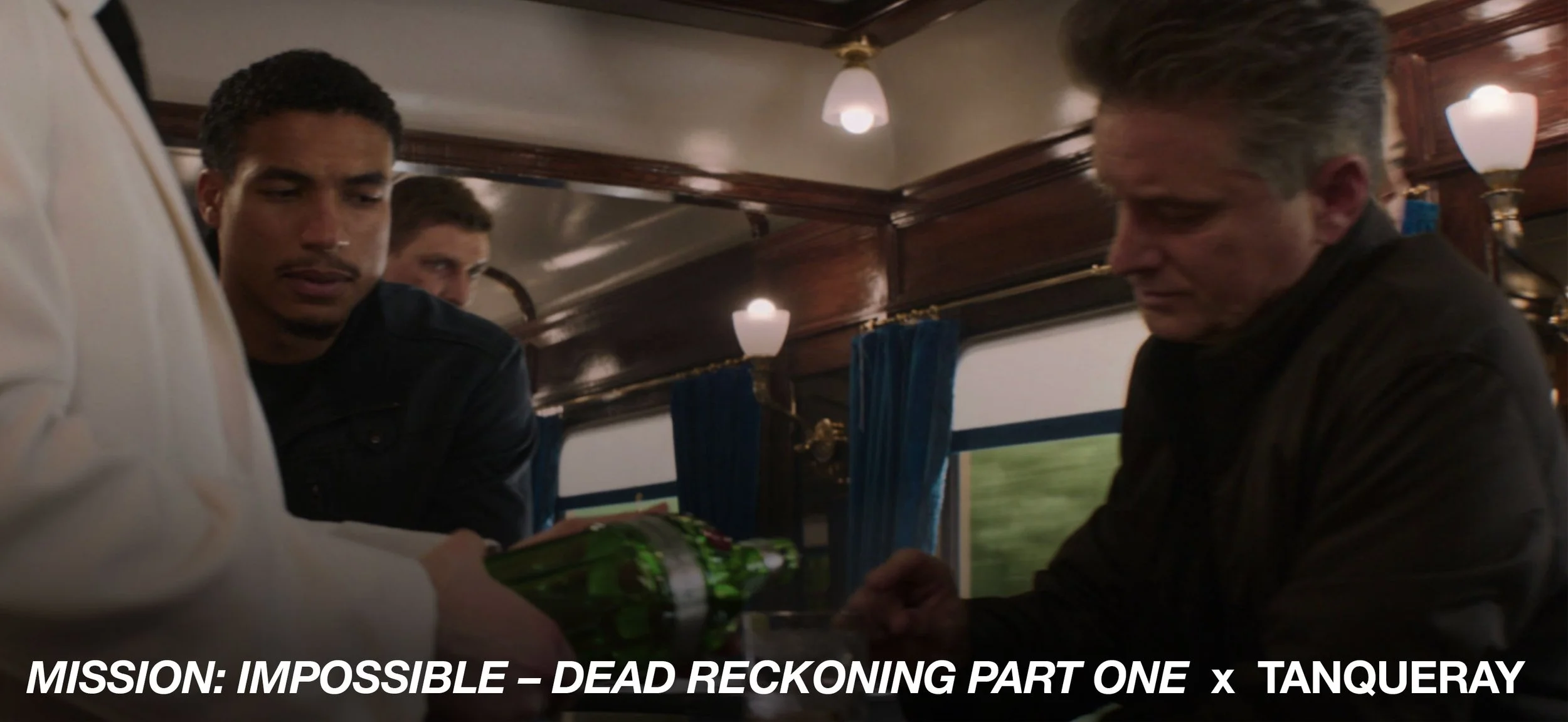 Three men on a train, with one holding a green object, possibly a weapon, while another appears to be handling a package or item, engaged in a serious exchange.