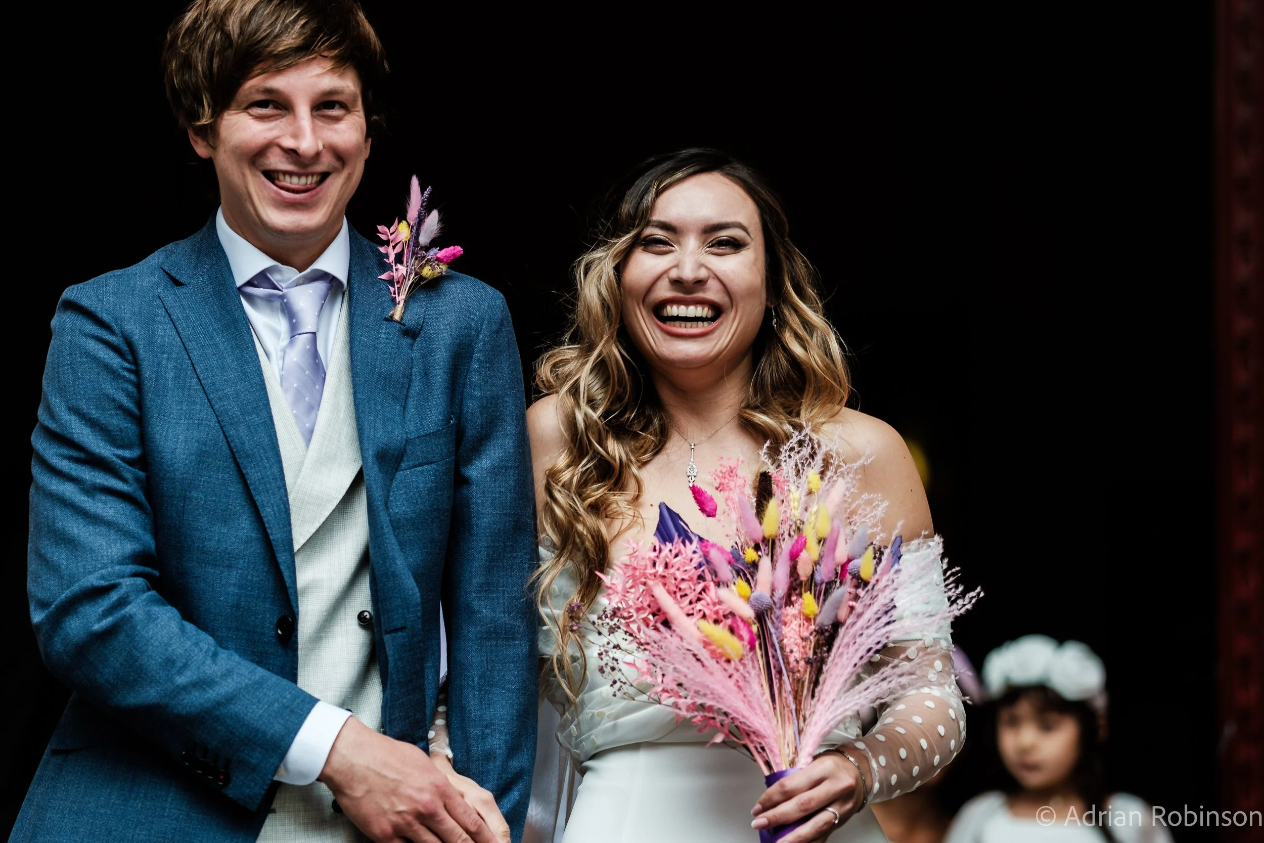 a happy young married couple emerge from a church in St. Pancras London