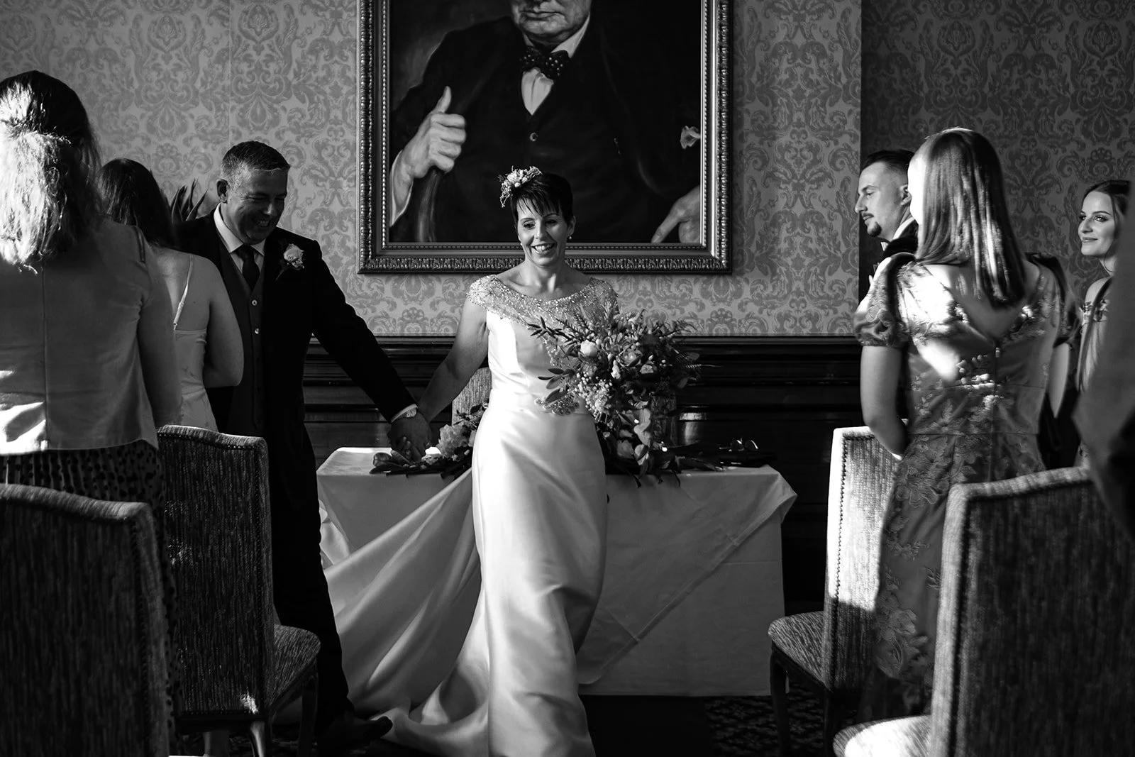 a black and white image of a couple leaving the ceremony room at the luton hoo hotel Bedfordshire