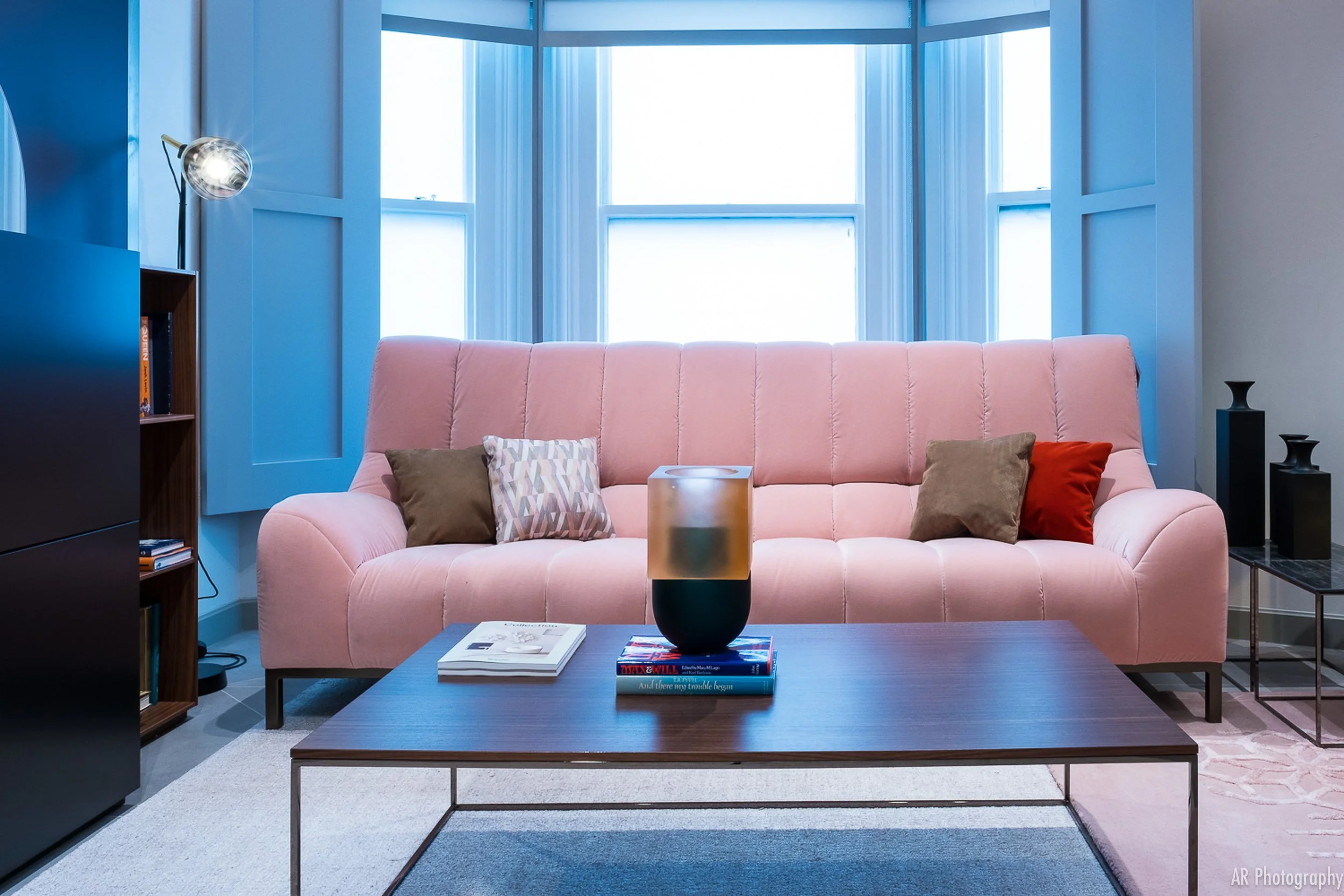 a Ligne Roset large pink velvet sofa in a furniture showroom in harrods London