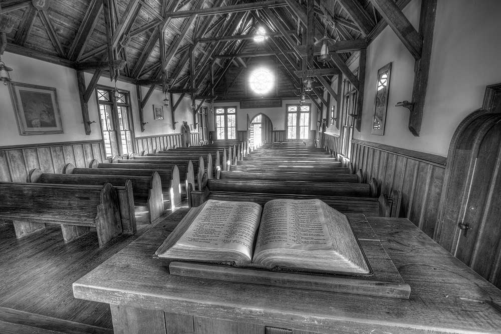 Black and white photo of the interior of Barnwell Chapel with a Bible in the foreground.