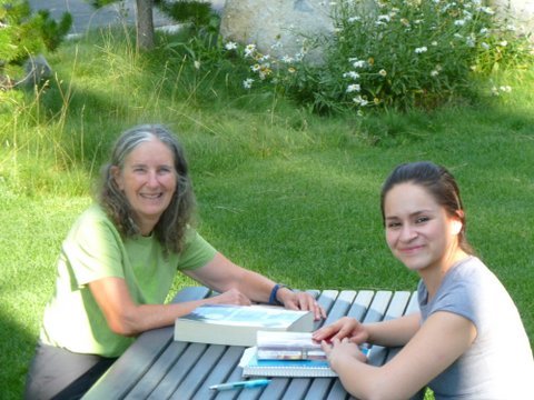 two women outside reading at library