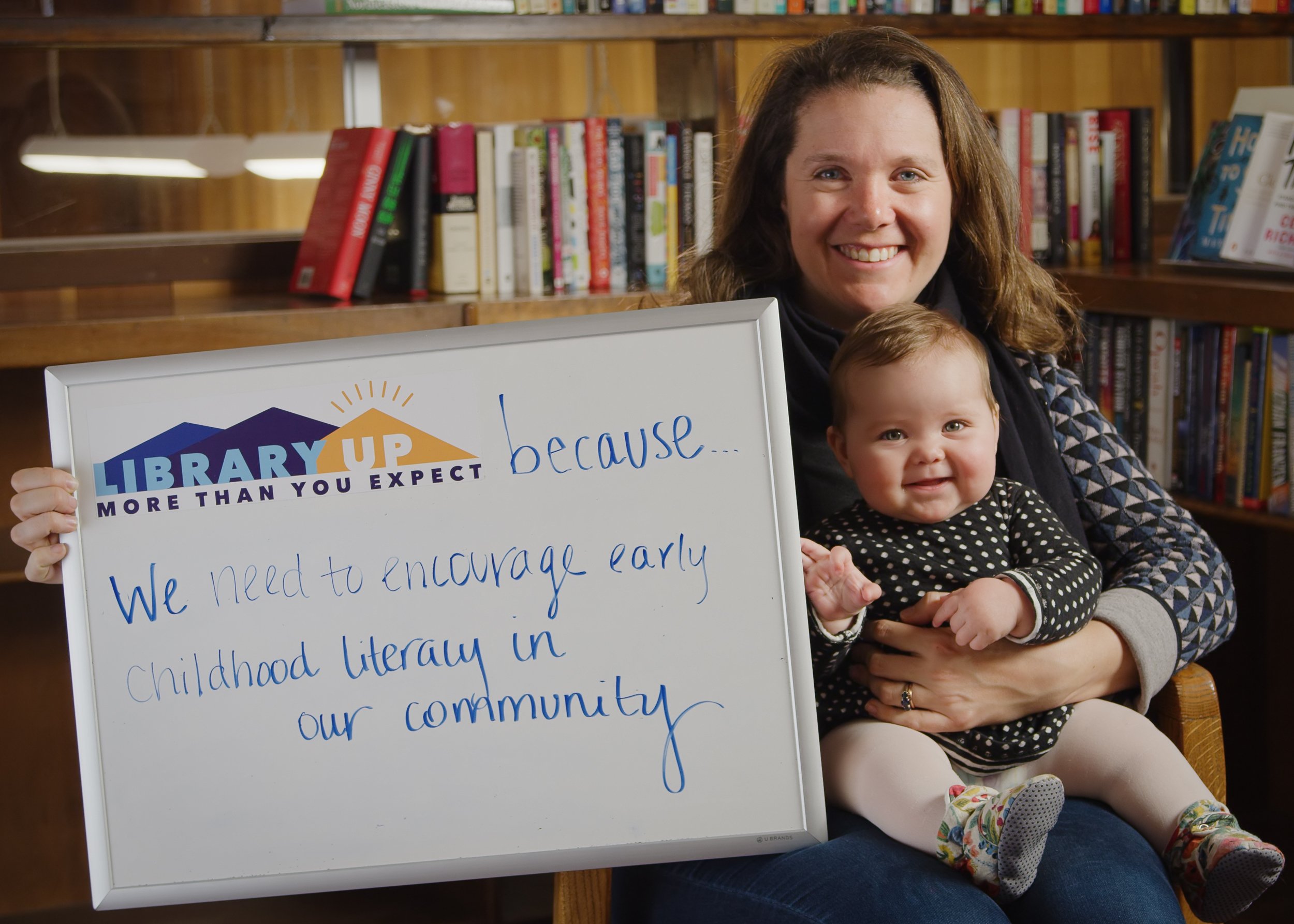 mom and baby holding whiteboard at library