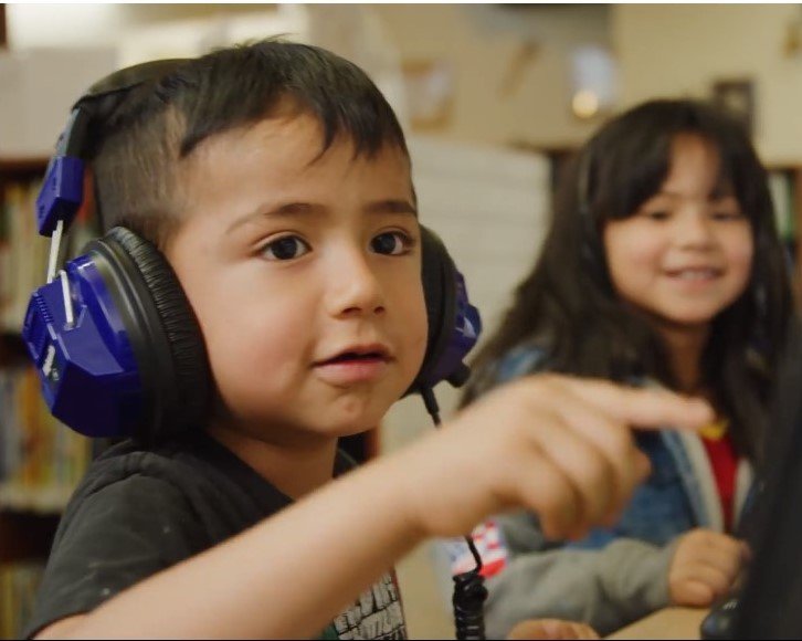 boy with headphones learning at library