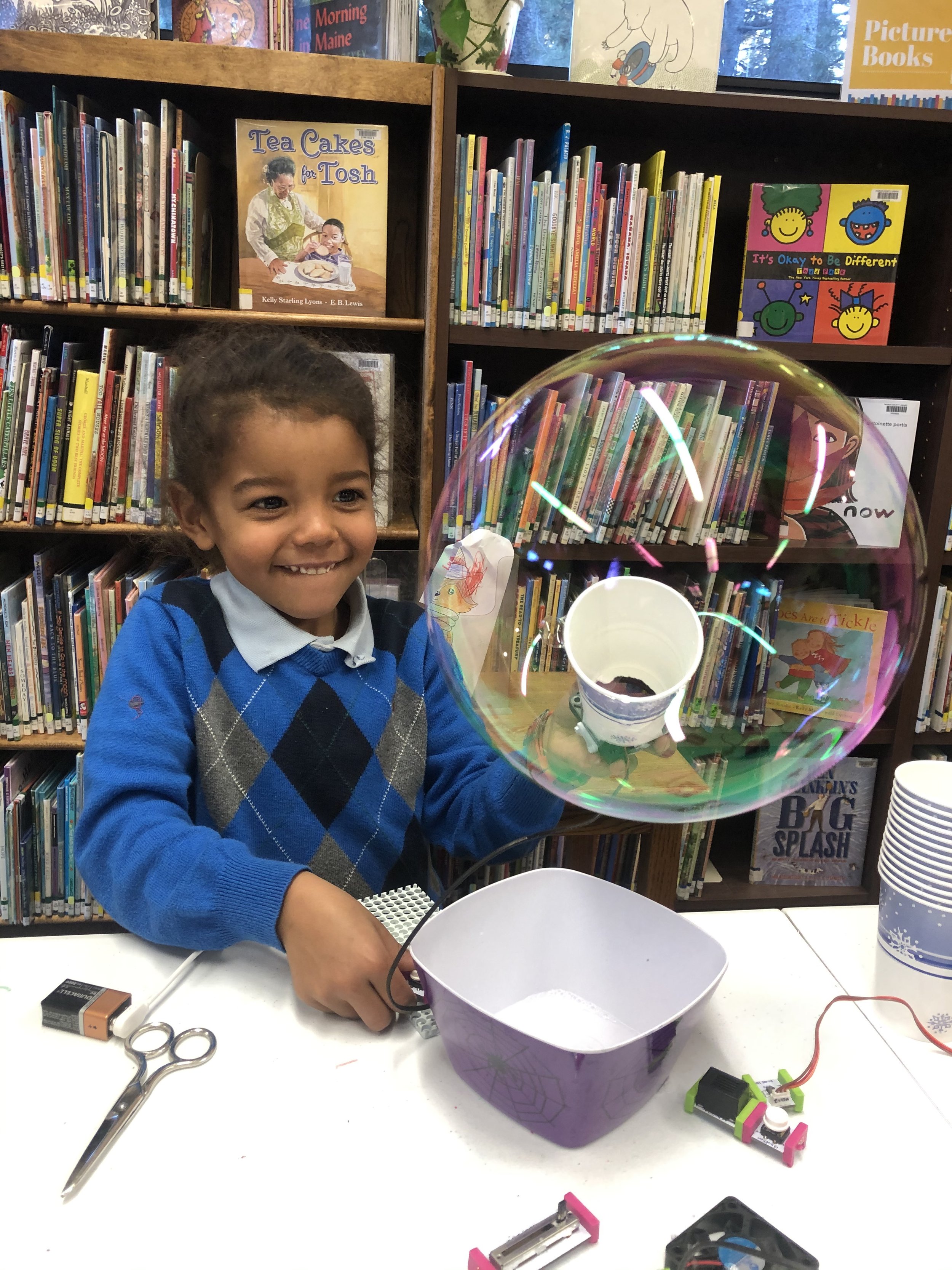 little boy doing science project at library