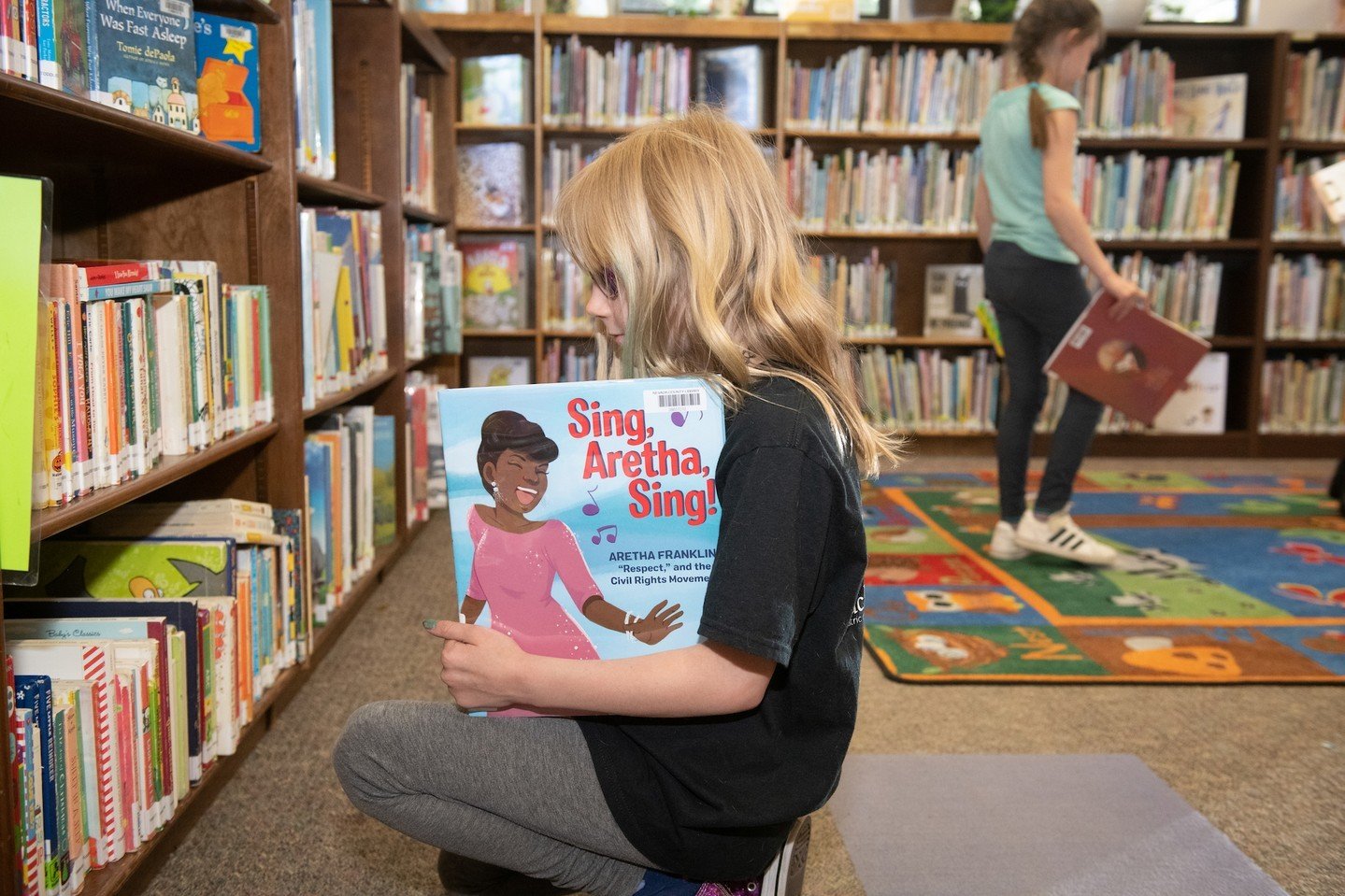 child picking out a library book