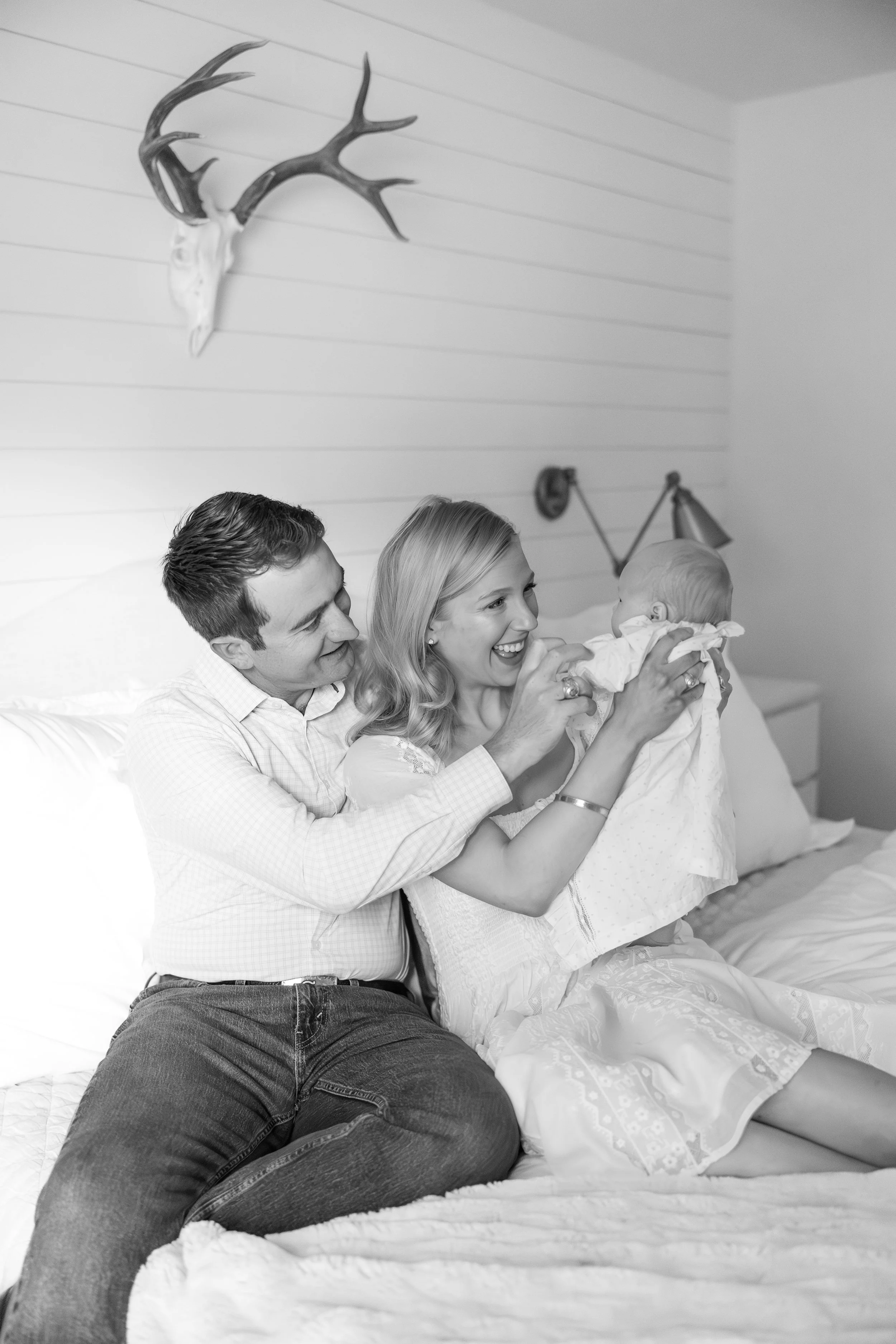 Austin newborn and family photography by Mandy Laine Photo: mother and father cradling their newborn in a cozy nursery, captured in natural light for tender, timeless moments.