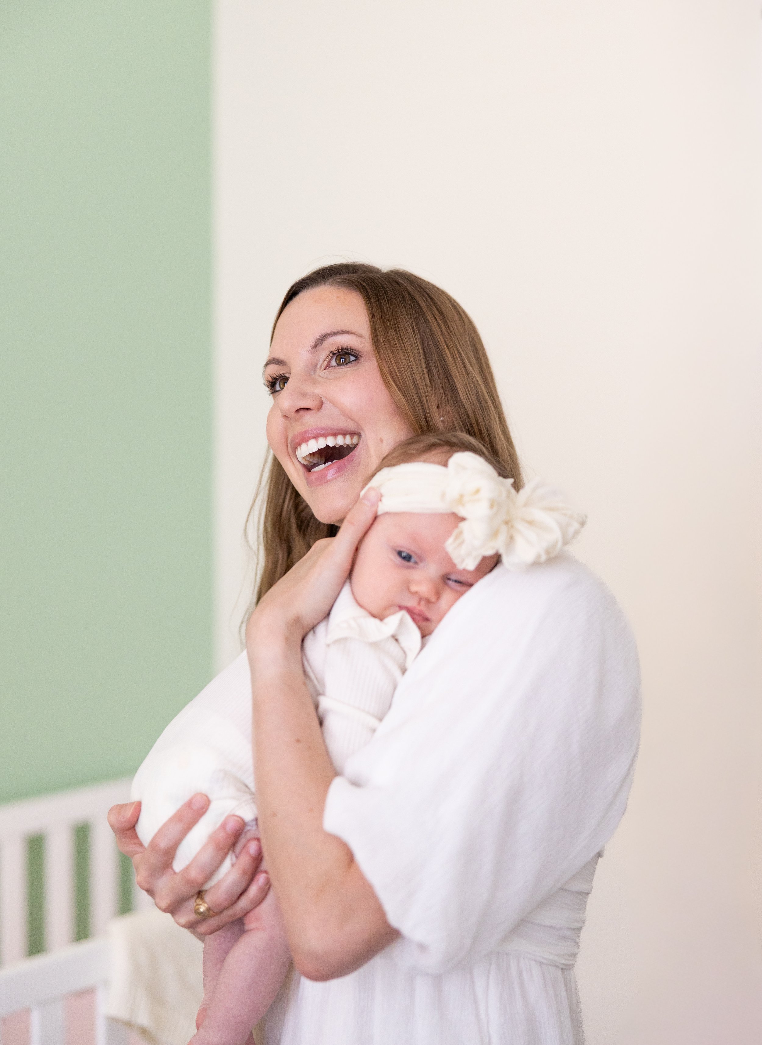 College Station maternity and newborn photography by Mandy Laine Photo: a mother cradles her newborn in a cozy nursery, captured in natural light for tender, timeless motherhood moments.