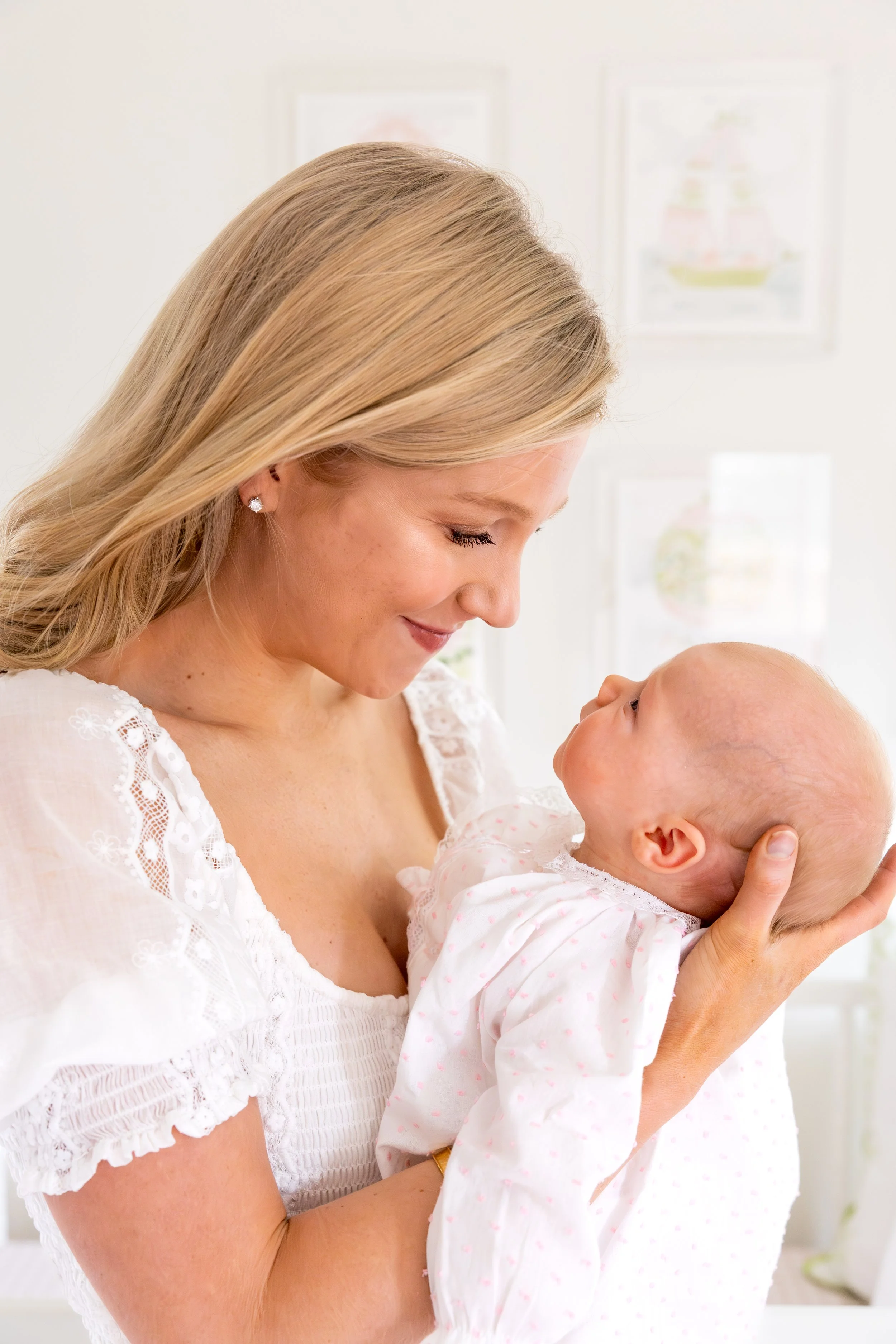 Mother cradling her newborn in a cozy nursery, captured in natural light to highlight tender, timeless motherhood moments captured by Mandy Laine Photo in Austin