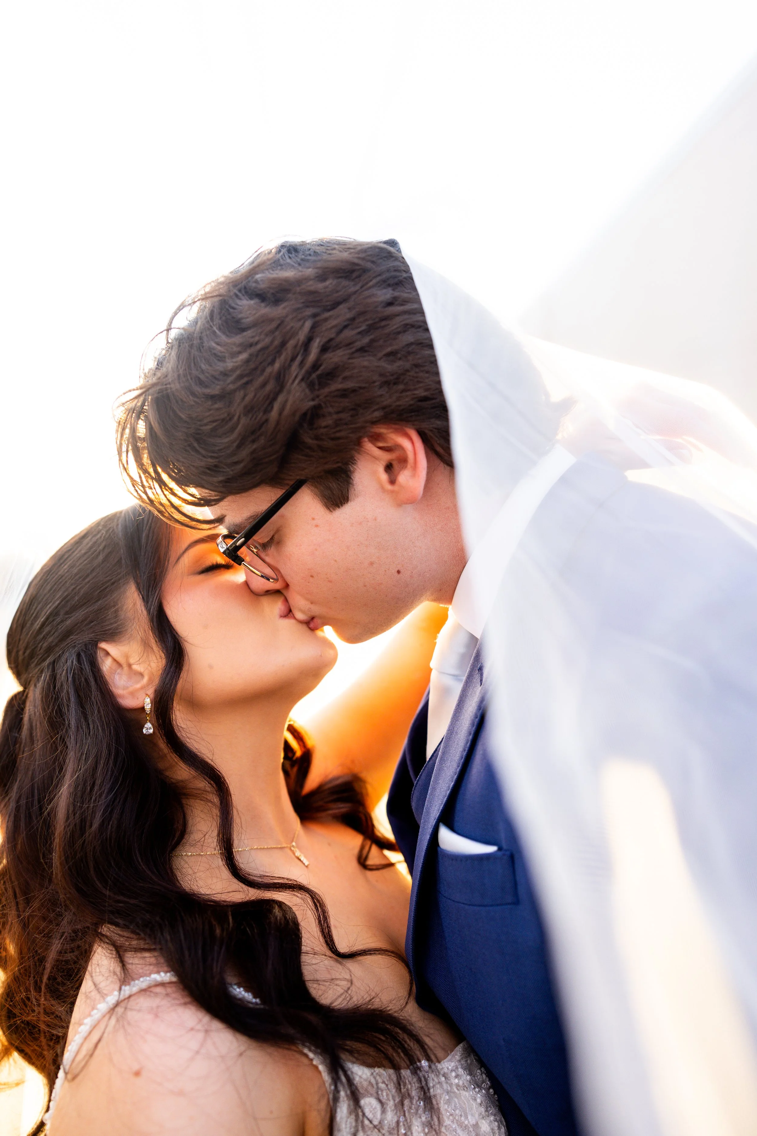 Bride and groom kissing outside in natural light at College Station wedding photographed by Mandy Laine Photo.