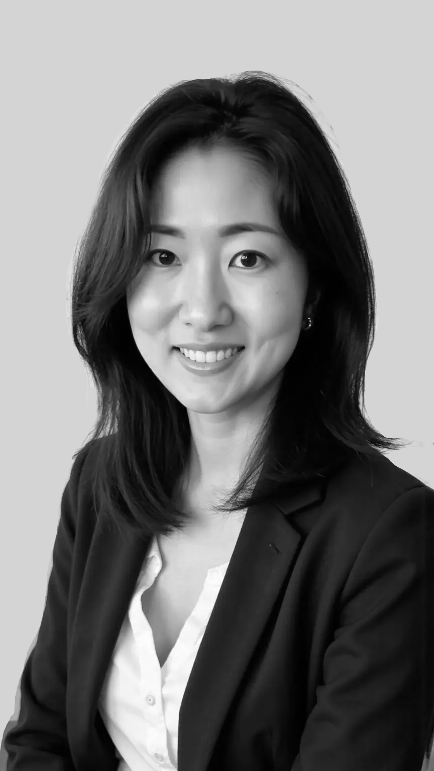 Black and white portrait of a smiling woman with shoulder-length hair, wearing a blazer and a collared shirt.