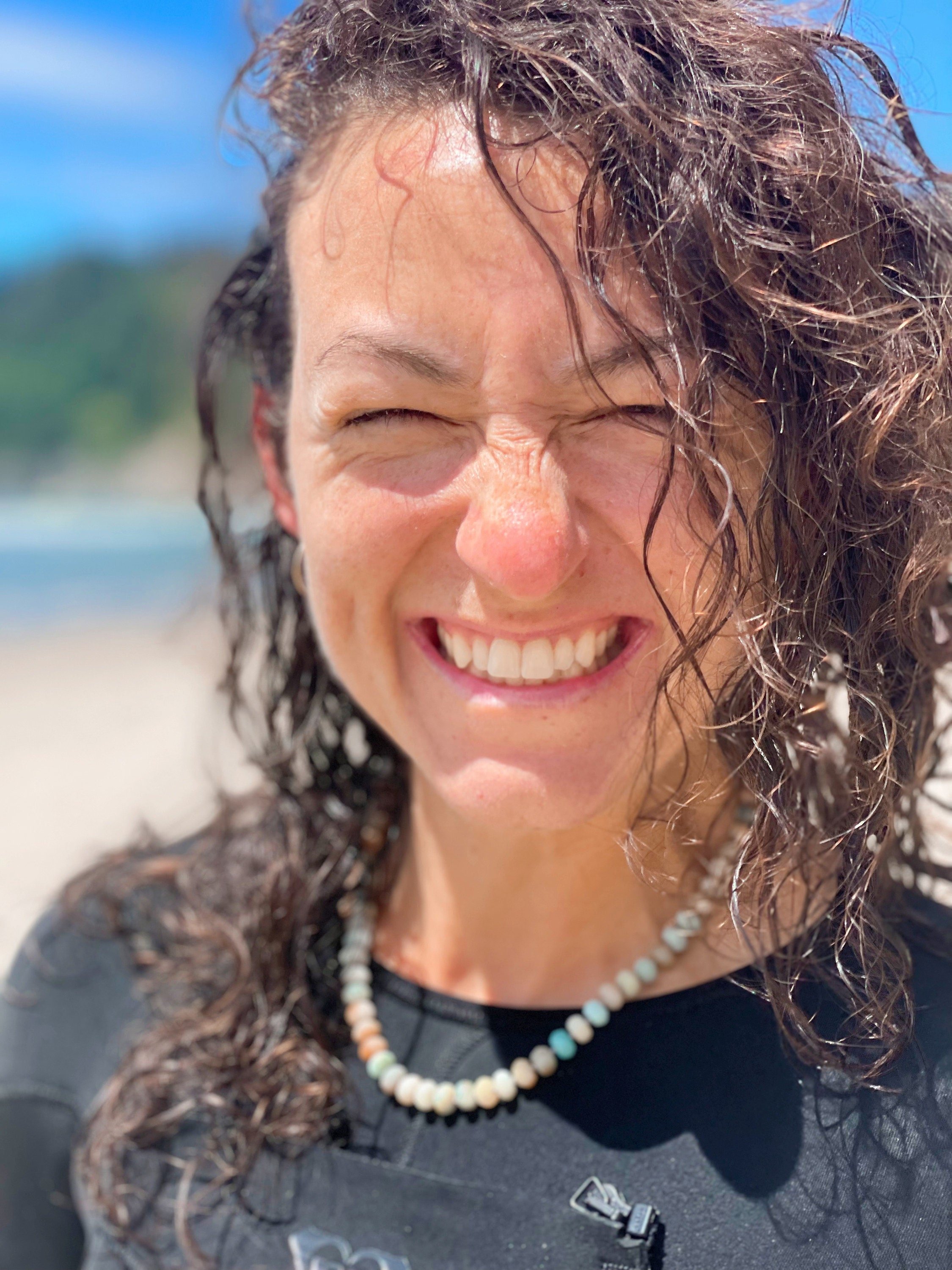 woman at the beach wearing necklace made of semiprecious gemstone mixed amazonite hand knotted with silk thread