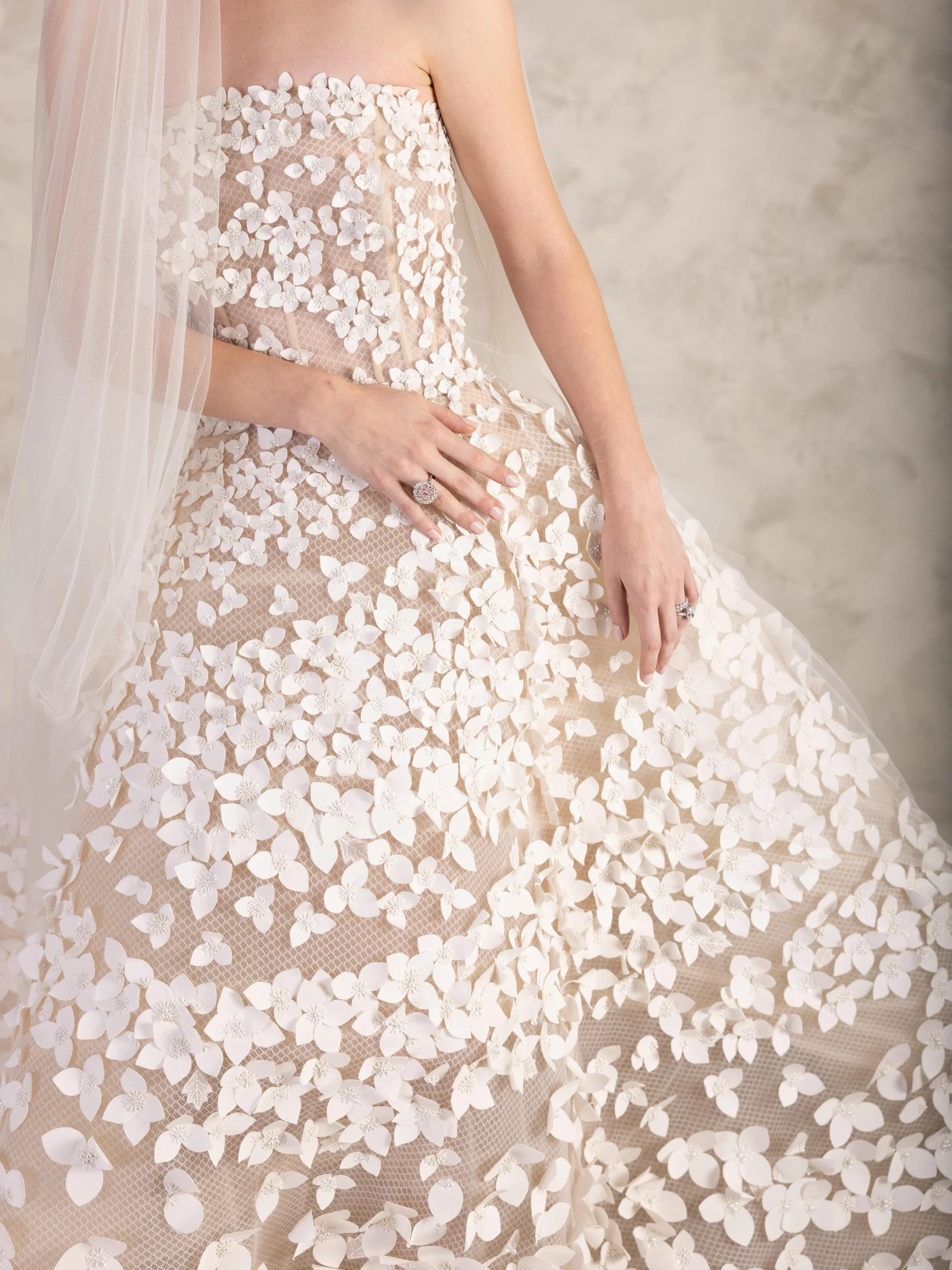 The iconic Petals gown by Oscar de la Renta, each petal carefully layered by hand onto a tulle foundation, creating the illusion of flowers blooming naturally across the silhouette. 

The creation of this single gown requires 349 hours of embroidery 