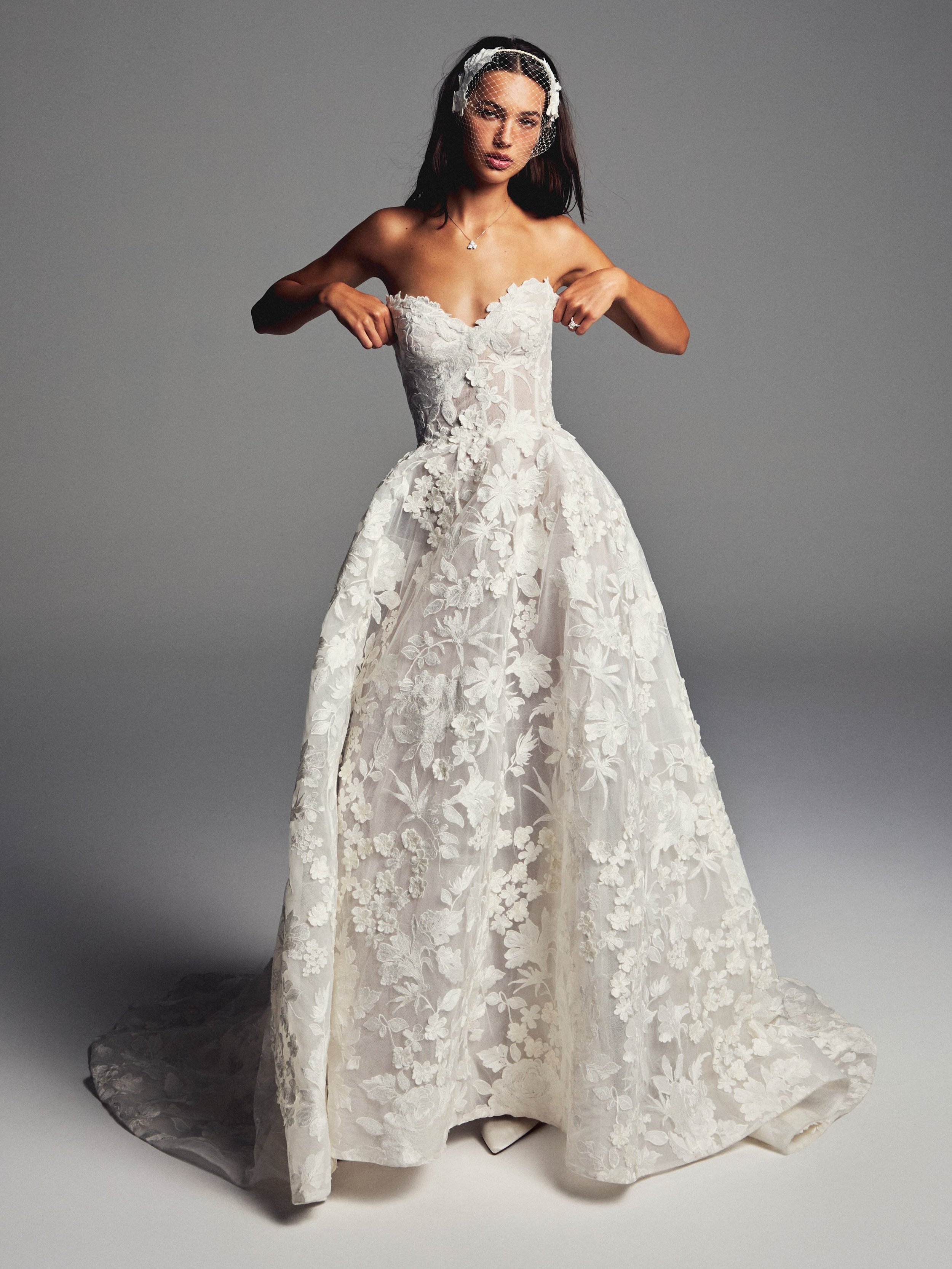 Meet June, a strapless ballgown with the most exquisite three dimensional floral embroidered lace. Discover the @moniquelhuillierbride Spring 2027 collection from November 6th-7th at our Trunk Show. Secure your private appointment now.