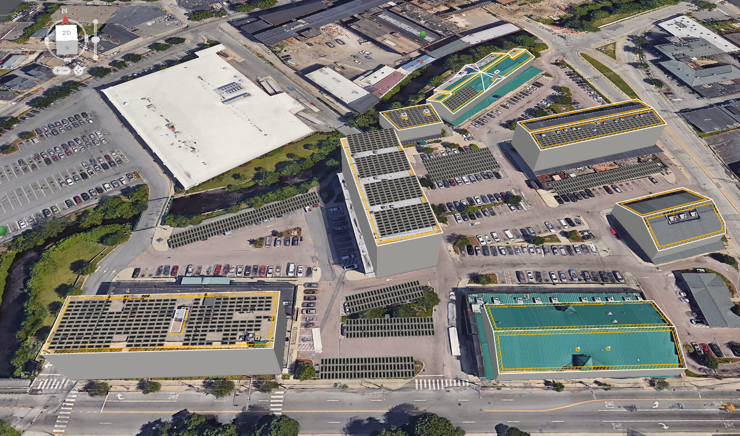 Aerial view of a commercial complex with multiple buildings, parking lots, and solar panel installations on rooftops. The area includes a large white-roofed building, smaller structures with ATF solar panels, and green spaces with trees.
