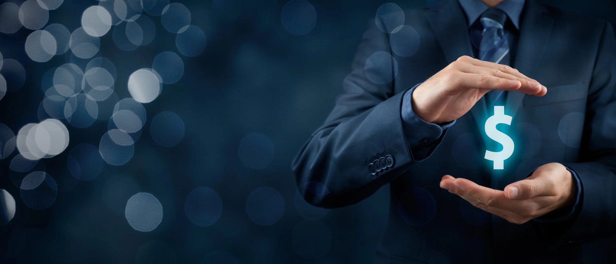 Businessman in a dark suit holding a glowing blue dollar sign hologram between his hands.