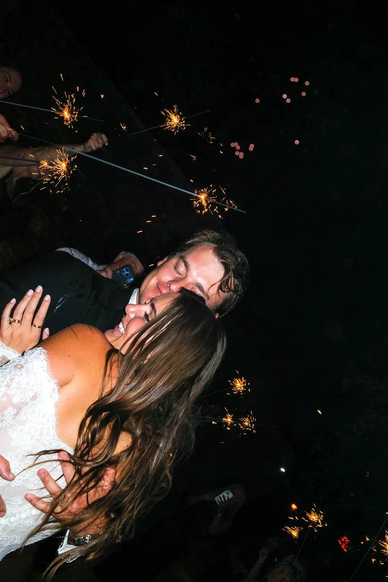 Couple hugging at a celebration with sparklers in the dark.