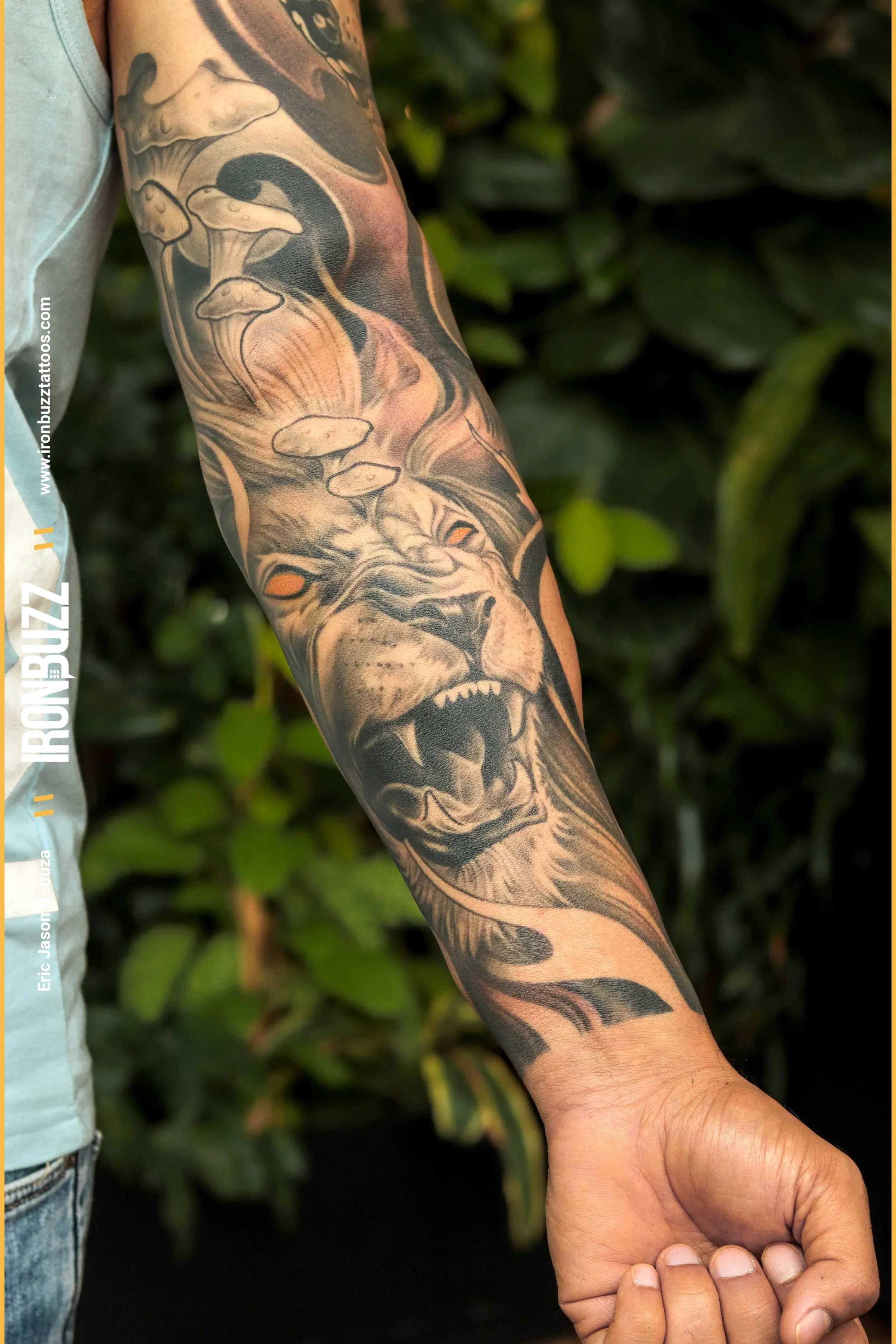 This detailed and full-hand-sized tattoo showcases the mighty image of a lion roaring in the wilderness. The lion is surrounded by a vibrant array of mushrooms, adding an element of mystique to the design. The tattoo is done in black and grey ink, cr