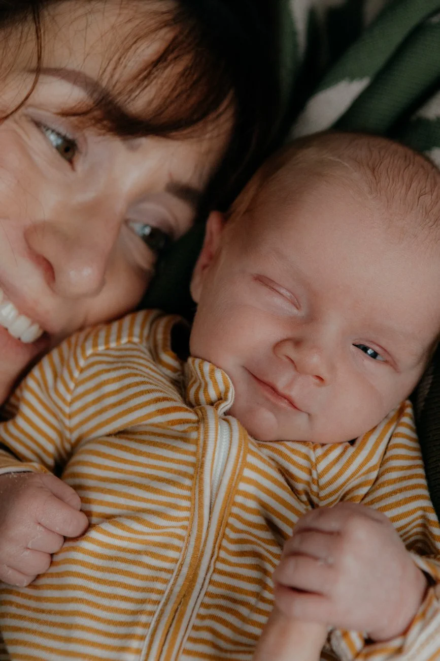 family-portraiture-mother-newborn-smiling-on-bed.001.jpg