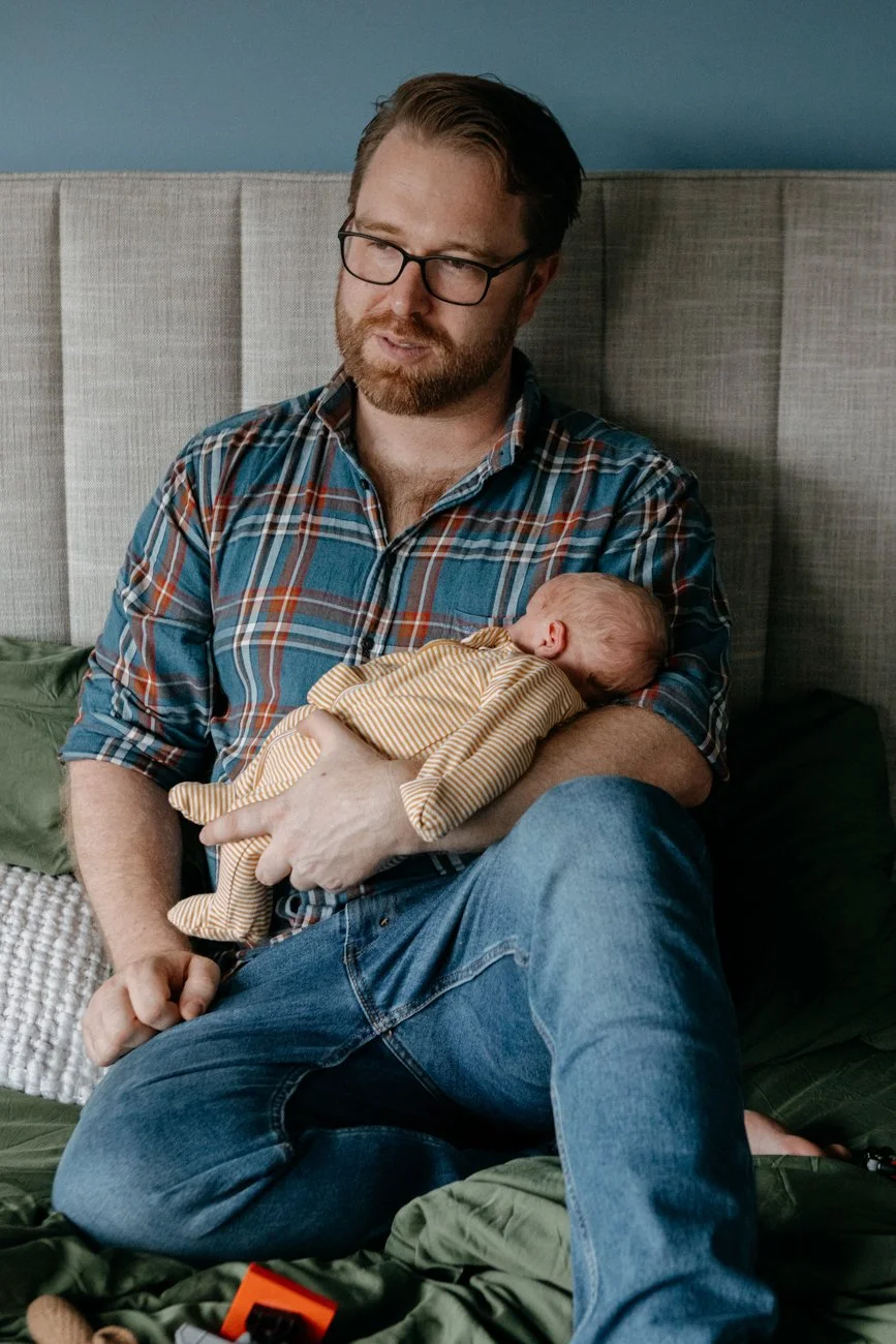 family-portraiture-father-holding-newborn-on-bed.002.jpg