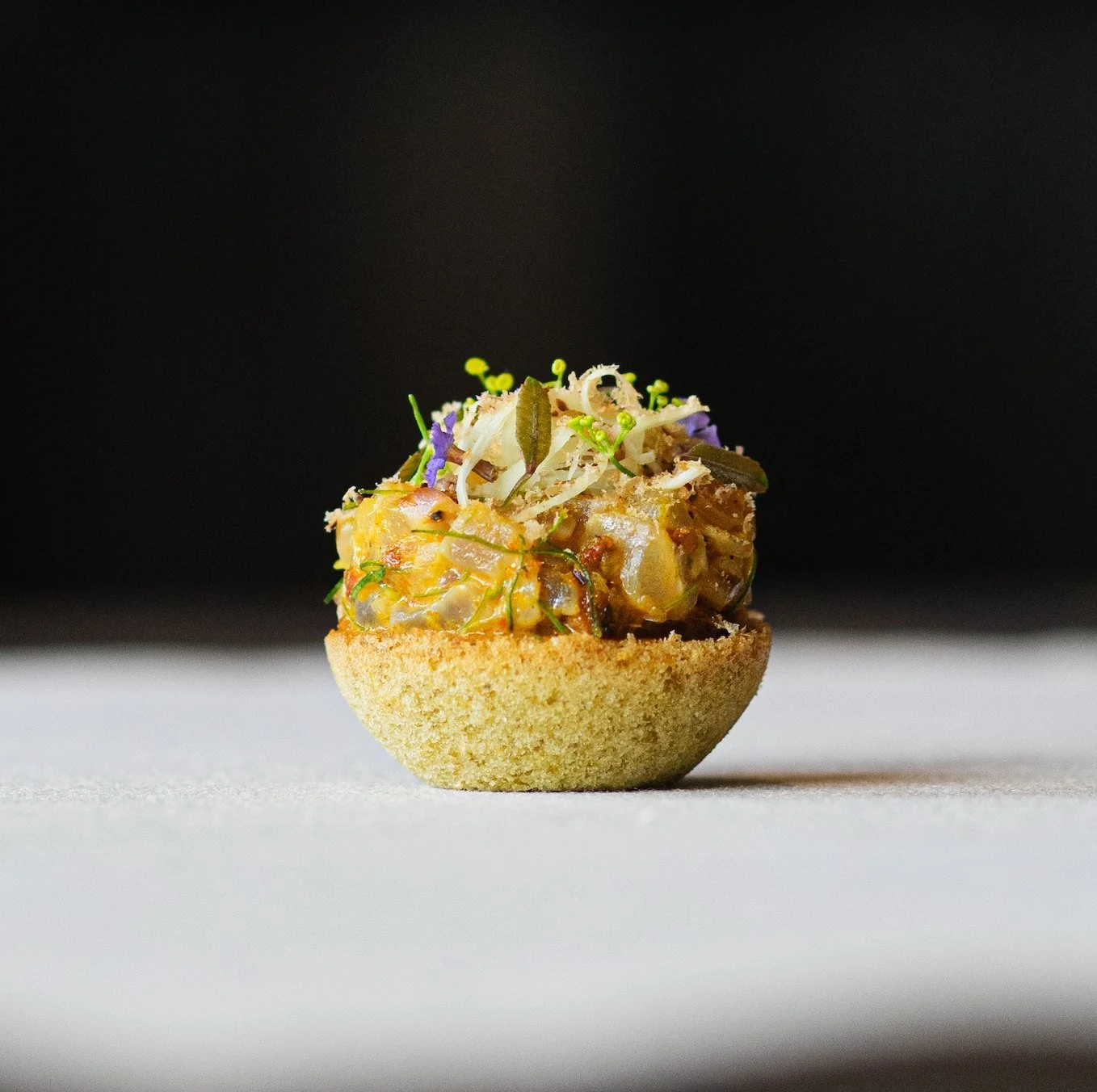 Close-up of a herb-topped tart canapé at Royd fine dining Phuket