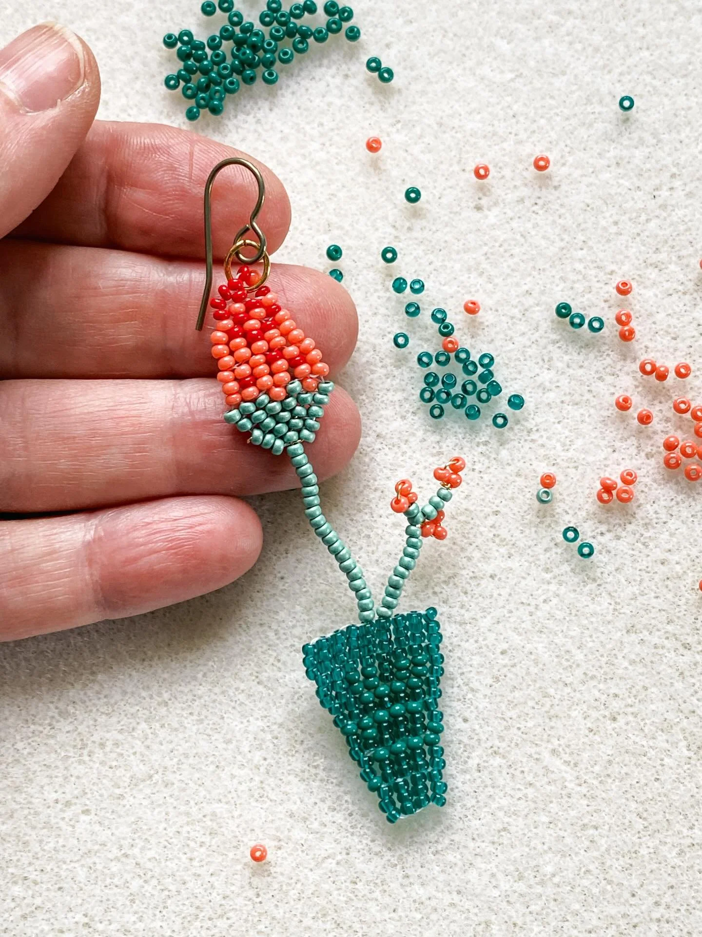 En ce moment, mon endroit pr&eacute;f&eacute;r&eacute;, c&rsquo;est ici.

Des perles vertes et corail &eacute;parpill&eacute;es sur la table.
Une fleur qui pousse doucement sous mes doigts.

Je pourrais faire autre chose.
Mais j&rsquo;ai envie d&rsqu