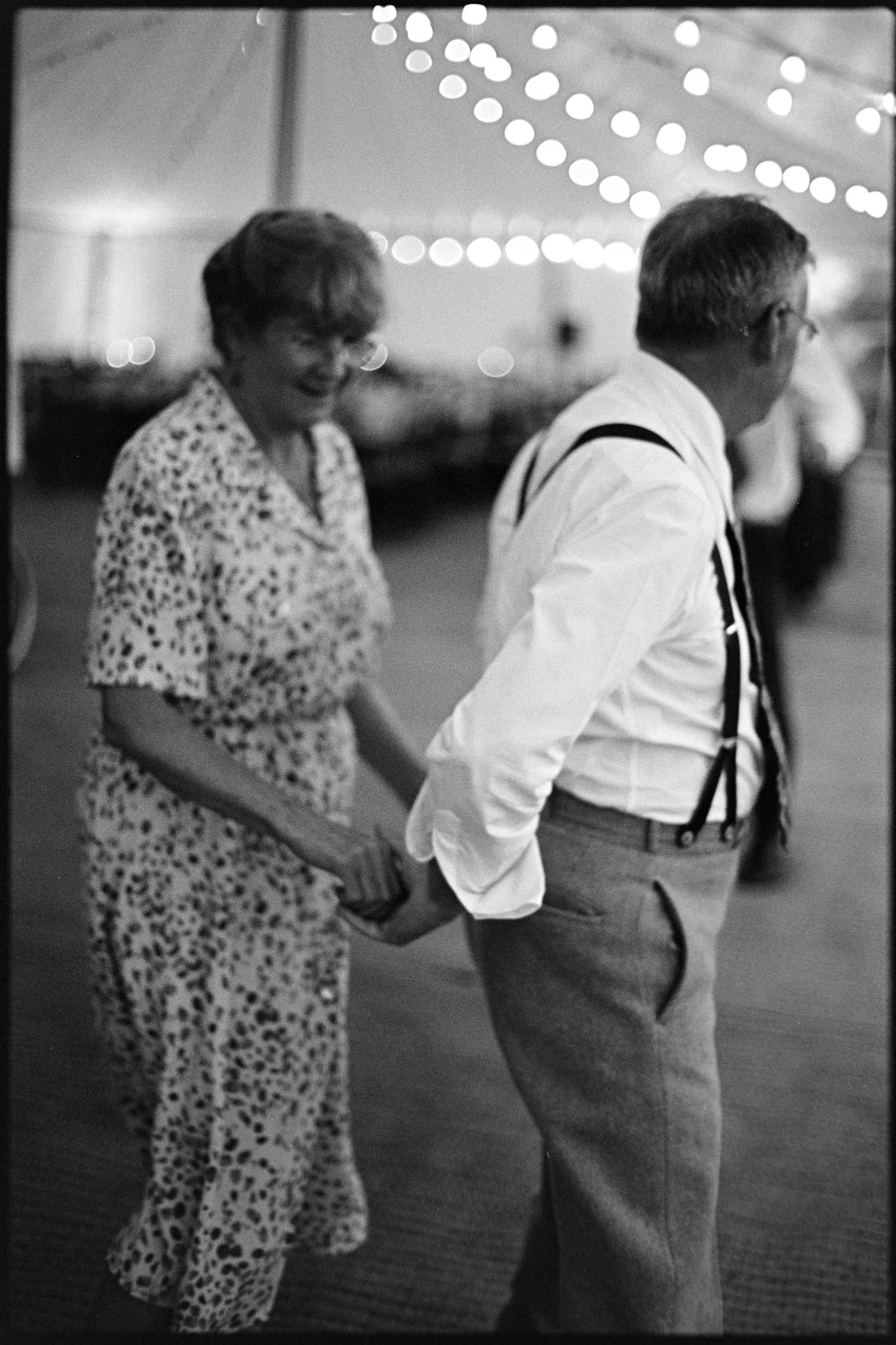 A mature couple dance at a wedding near Bristol in black and white, shot on tri-x film with great bokeh