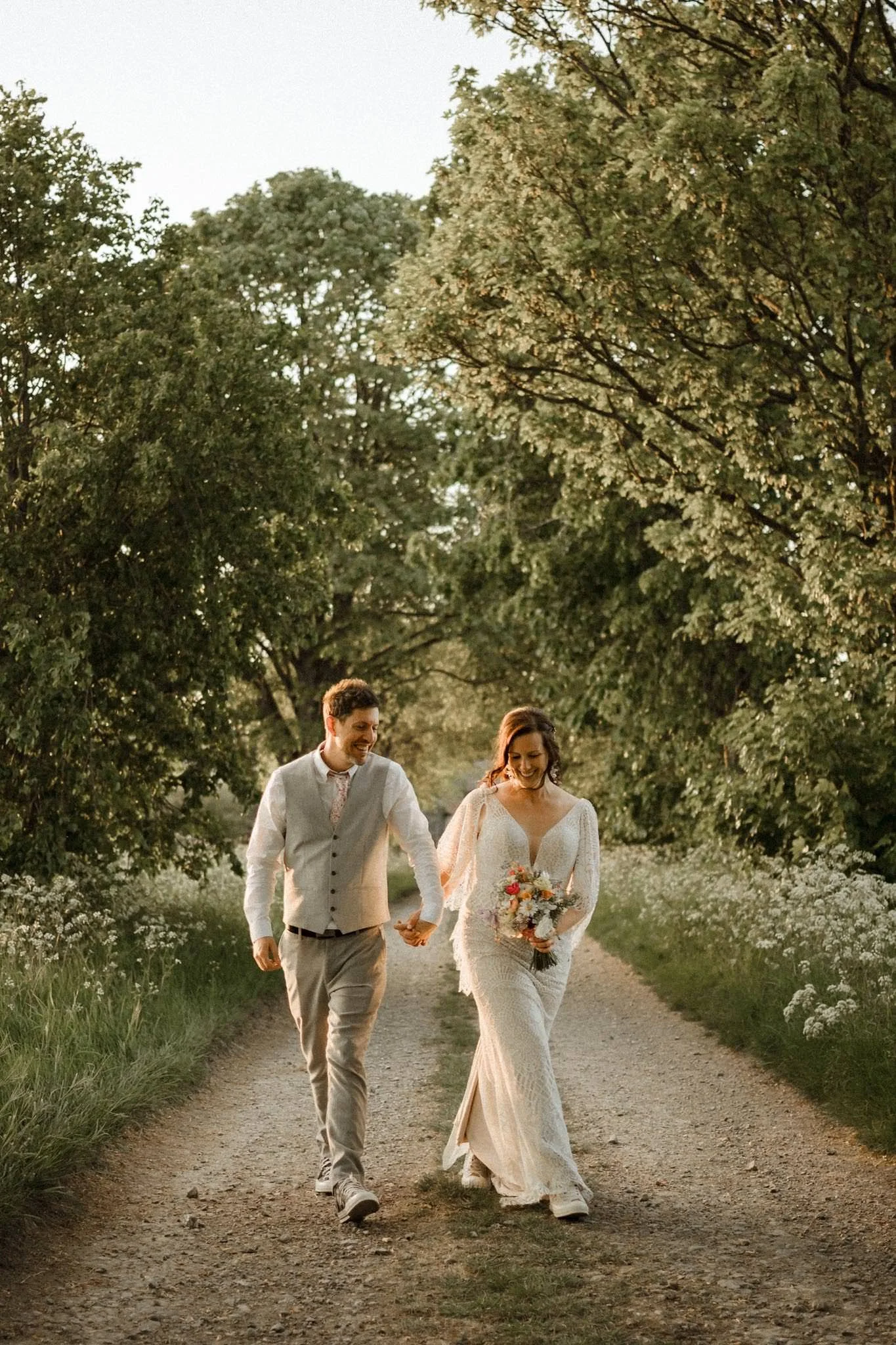 Bride and groom walking at sunset on their wedding day by Bristol wedding photographer