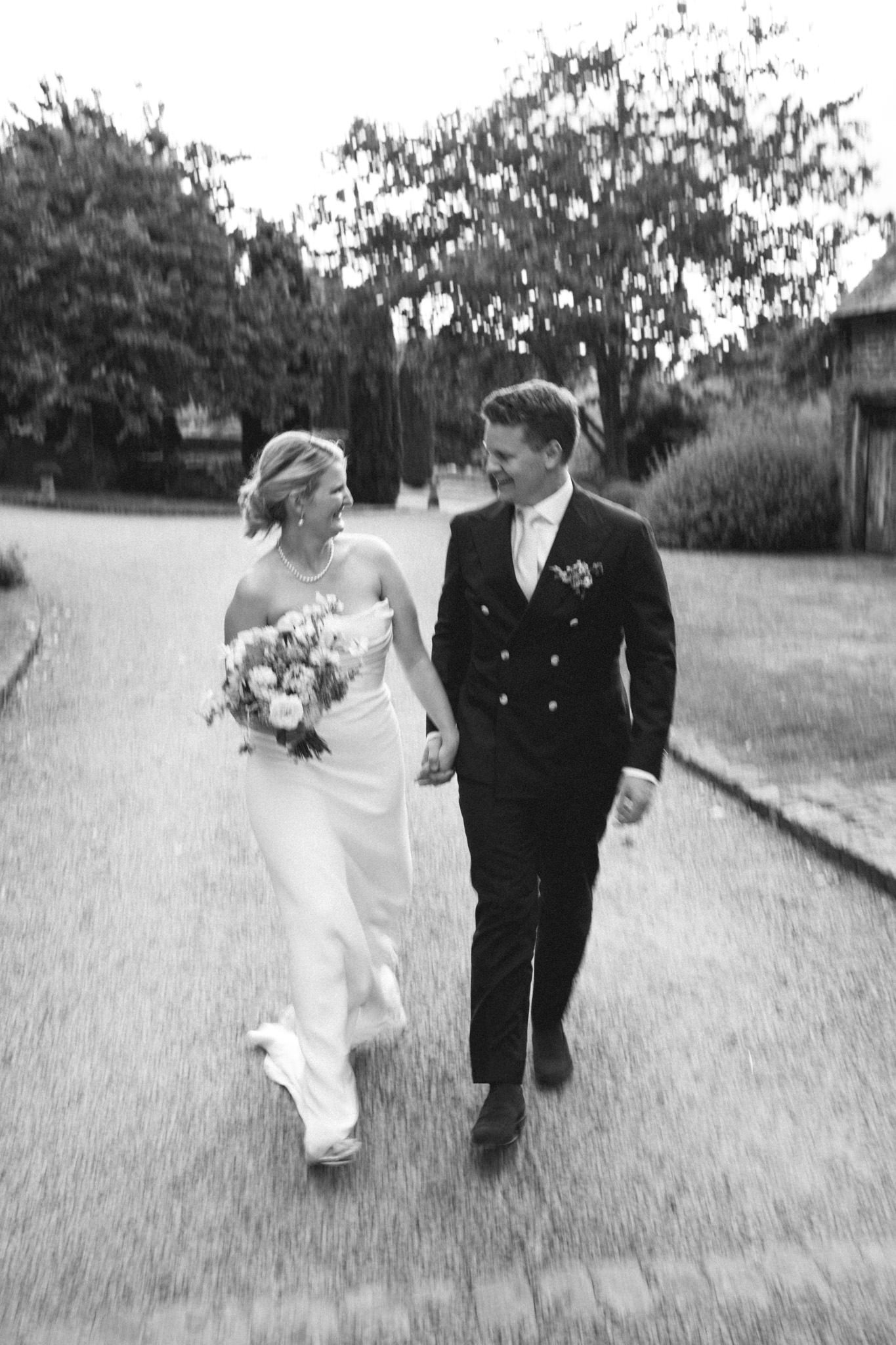 wedding photography of bride and groom walking toward the camera at Dewsall Court