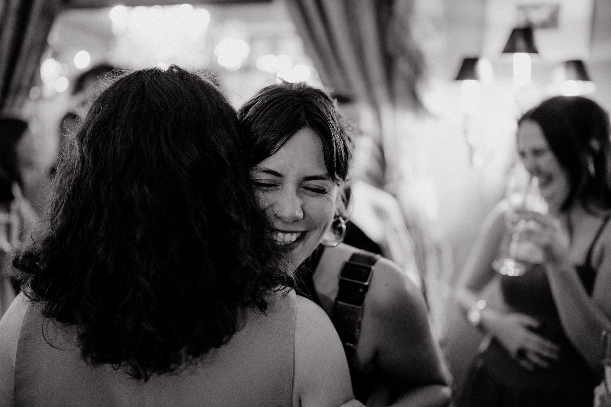 wedding photography of a female guest laughing in black and white