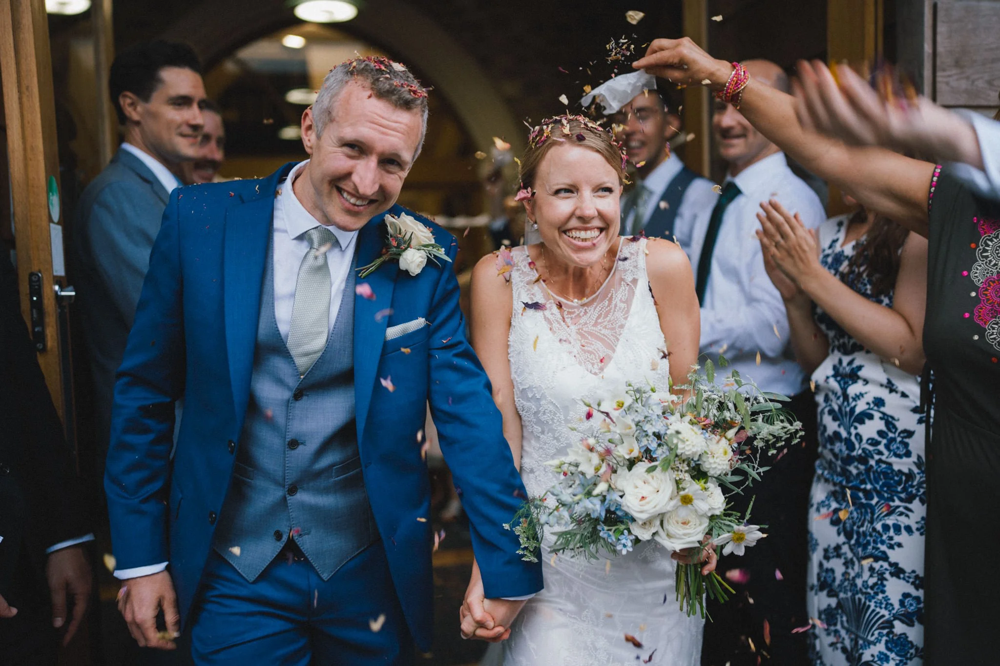wedding photography of a couple ducking confetti and Woodlands Church in Bristol
