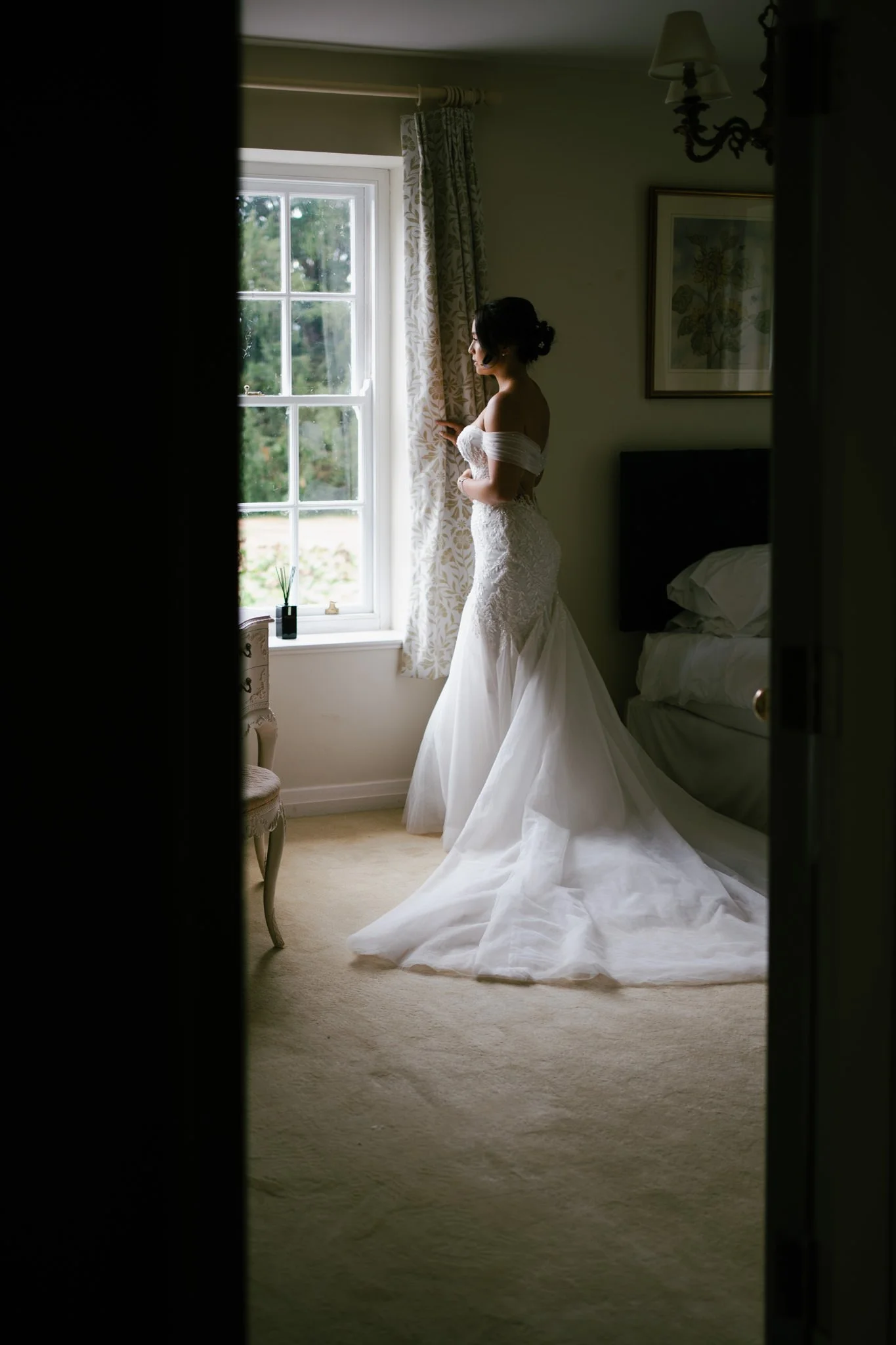 Beautiful young bride waits by a window at Birtsmorton Court