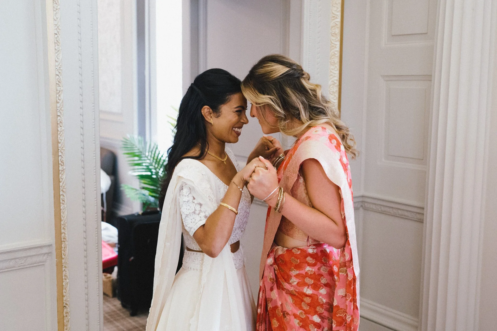 wedding photography of a Sri Lankan bride embracing with a bridesmaid at Hensol Castle