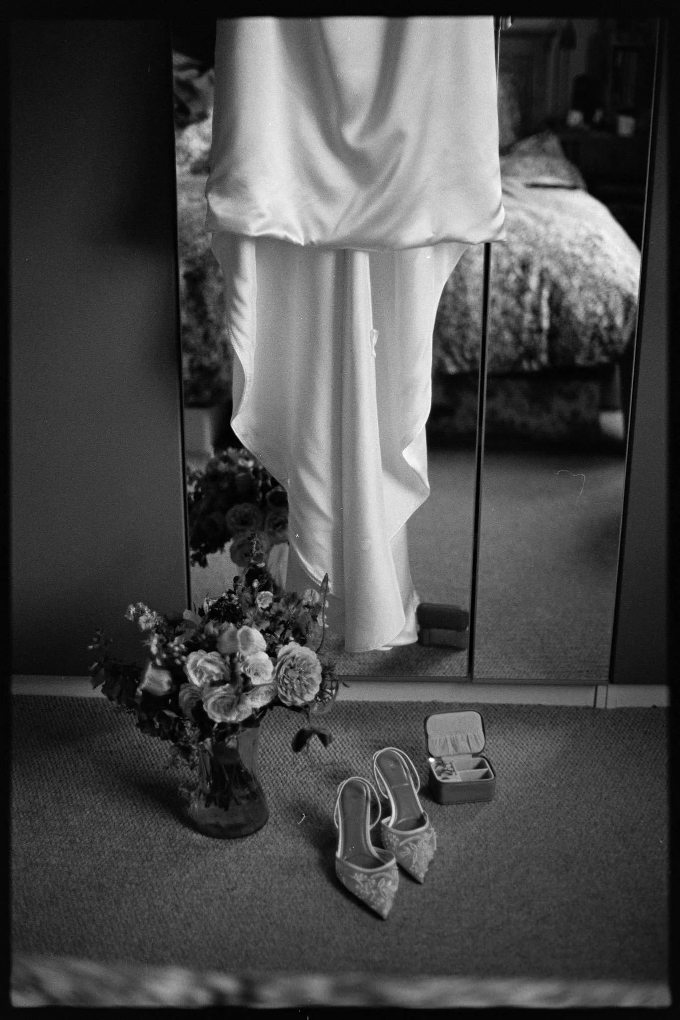 Analogue wedding photo of a dress, shoes and flowers in front of a mirror during getting ready, shot on Tri-x film just outside Bristol