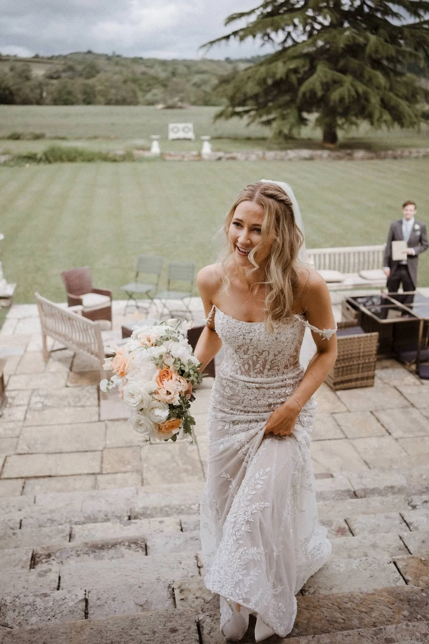 Beautiful blonde bride walking up steps at Llangoed Hall in Wales