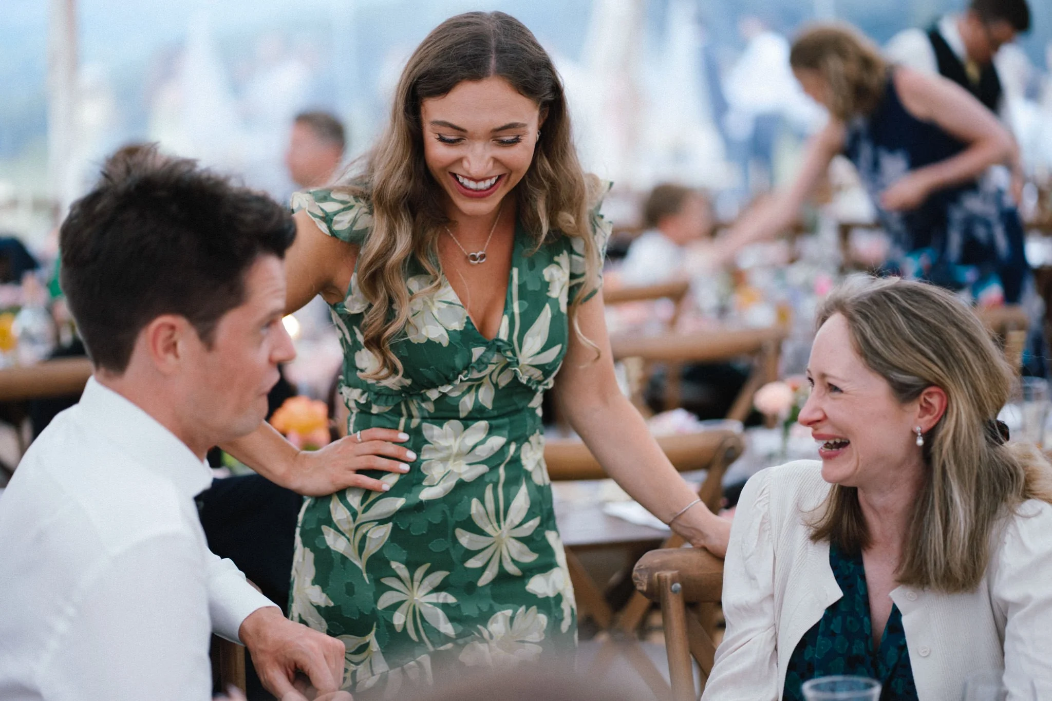 wedding photography of guests laughing at the dining table