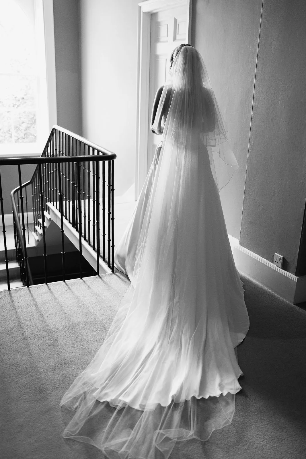 Bride waiting at top of staircase before first look with her father