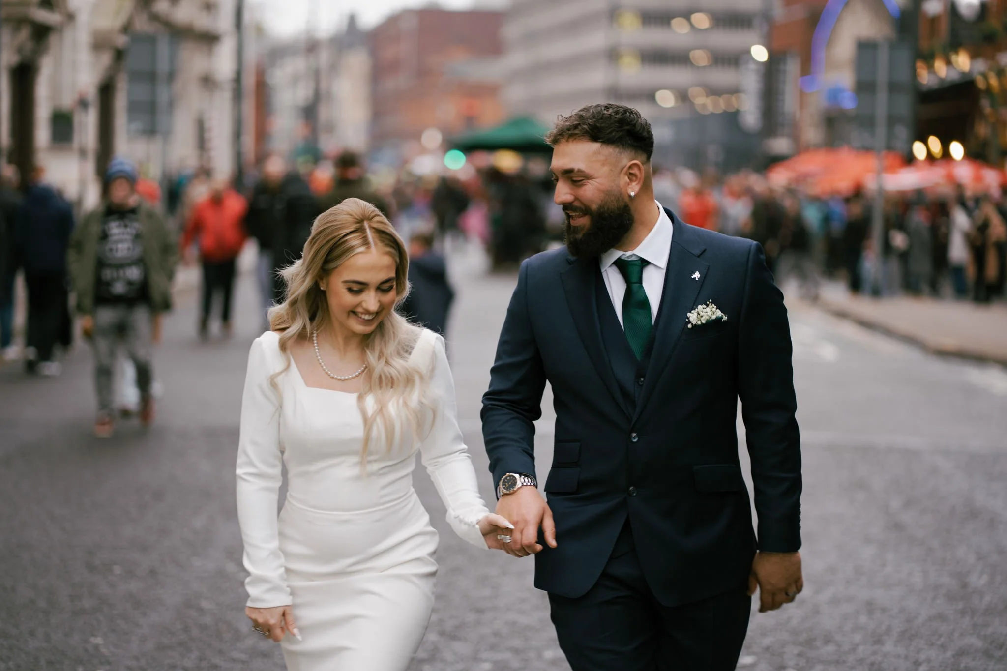 Bride and groom walking together through Cardiff during a rugby match at the millennium stadium