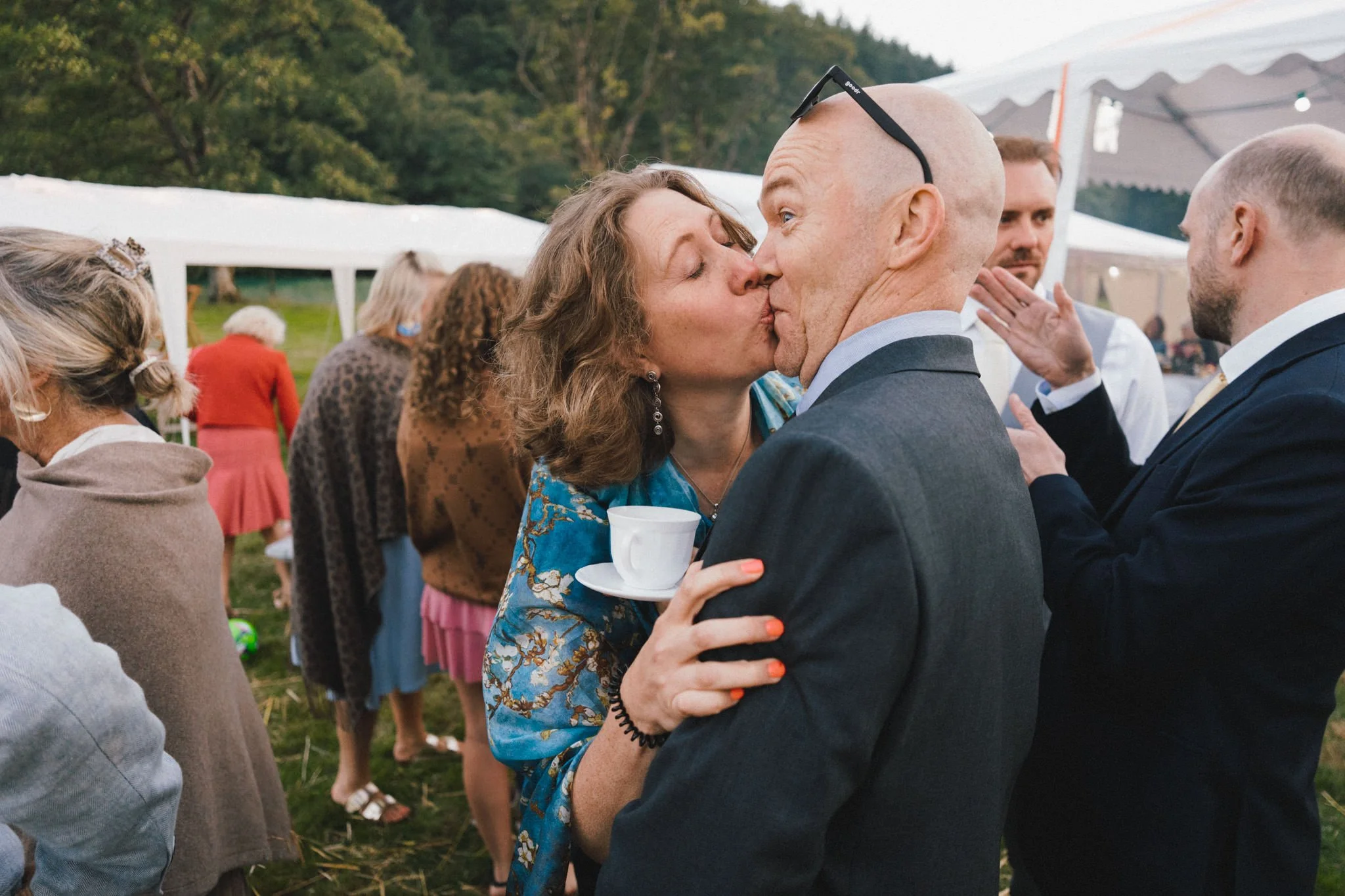 wedding photography of a couple kissing and making a funny face at a marquee wedding in Wales