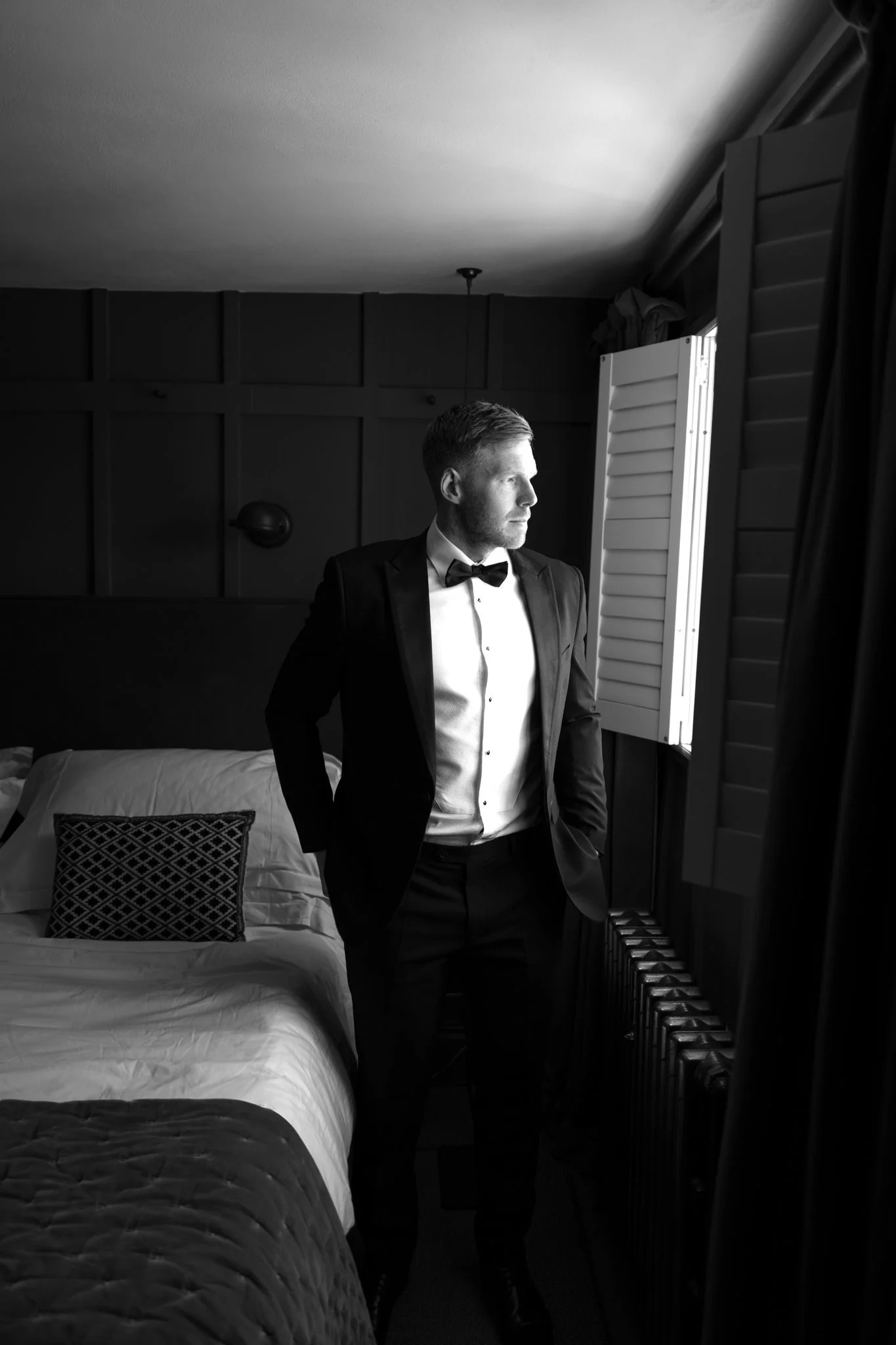 wedding photography of a groom by a window in black and white at No 131 Cheltenham