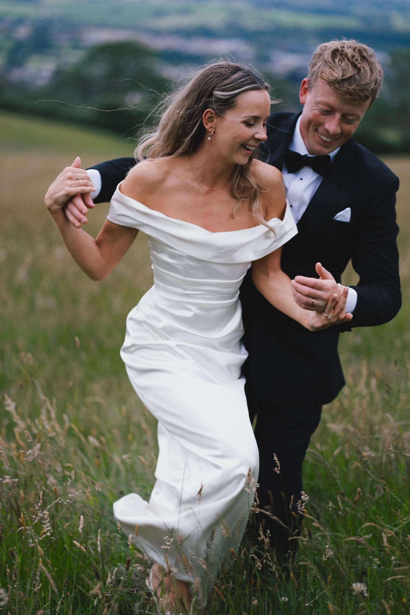 wedding photography of bride and groom having fun together in a field in Somerset at sunset