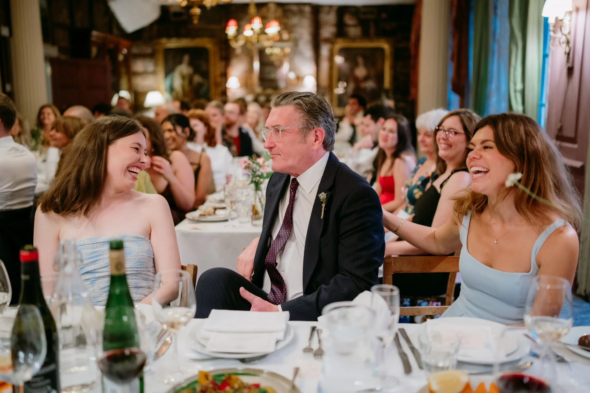 Laughing bridesmaids and father of the bride during speeches at Brunswick House in London