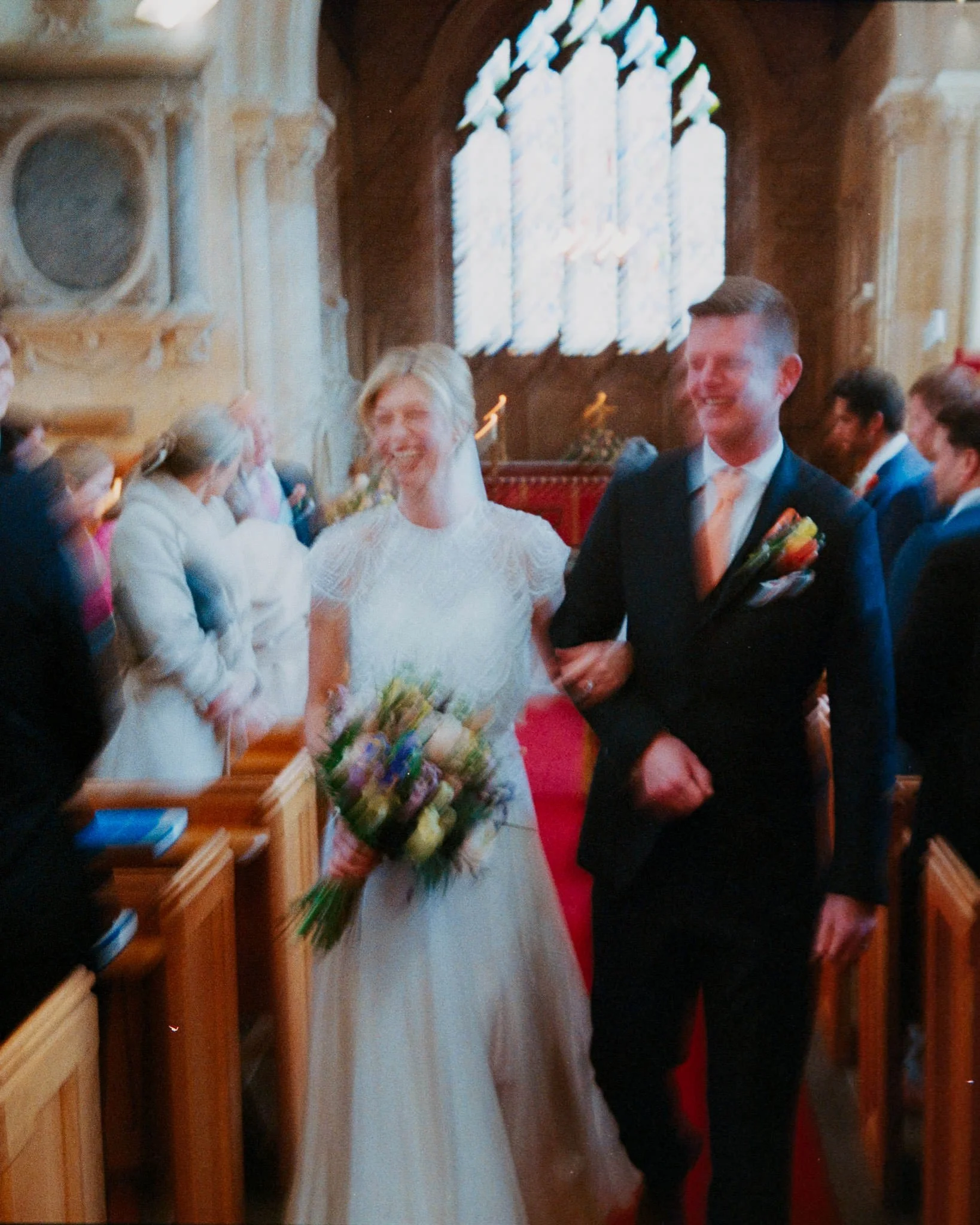 Bride and groom with lots of motion blur walking down the aisle at Blockley Church at a cotswold wedding