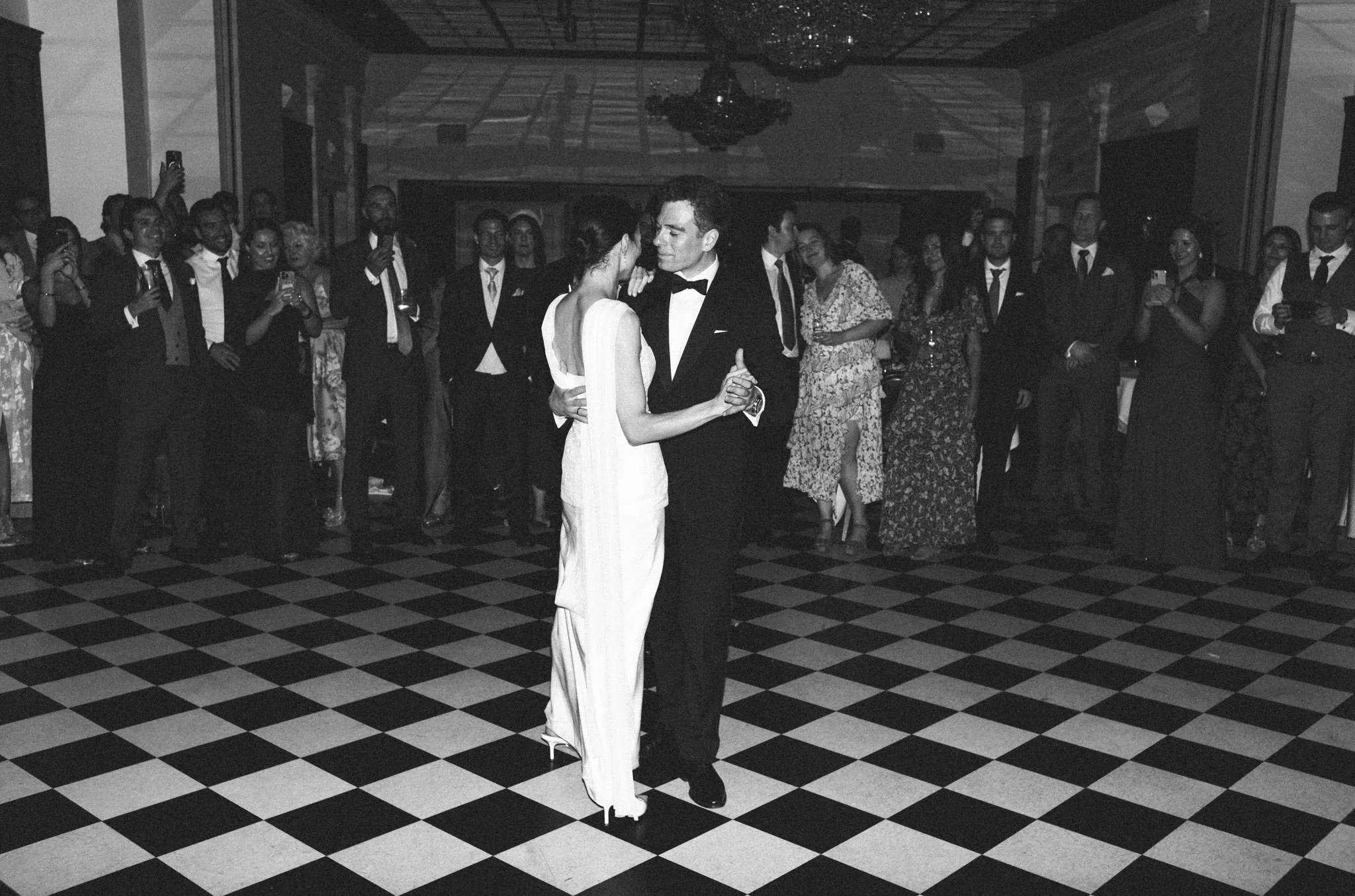 Bride and groom on the dancefloor at the Randolph Hotel in Oxford with a check patter on the floor heading backwards.